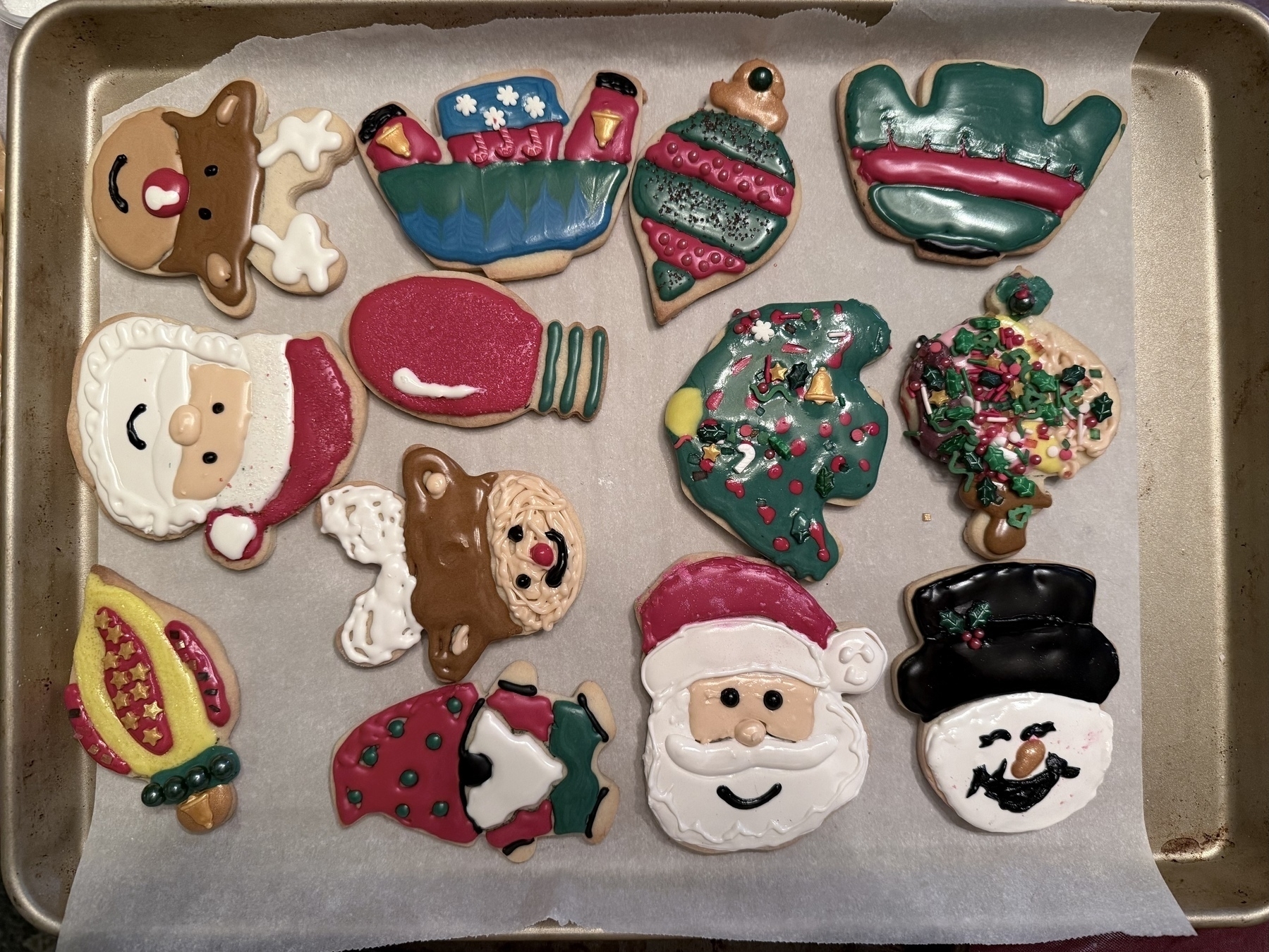 Auto-generated description: A baking sheet displays a variety of colorful, decorated Christmas-themed cookies.