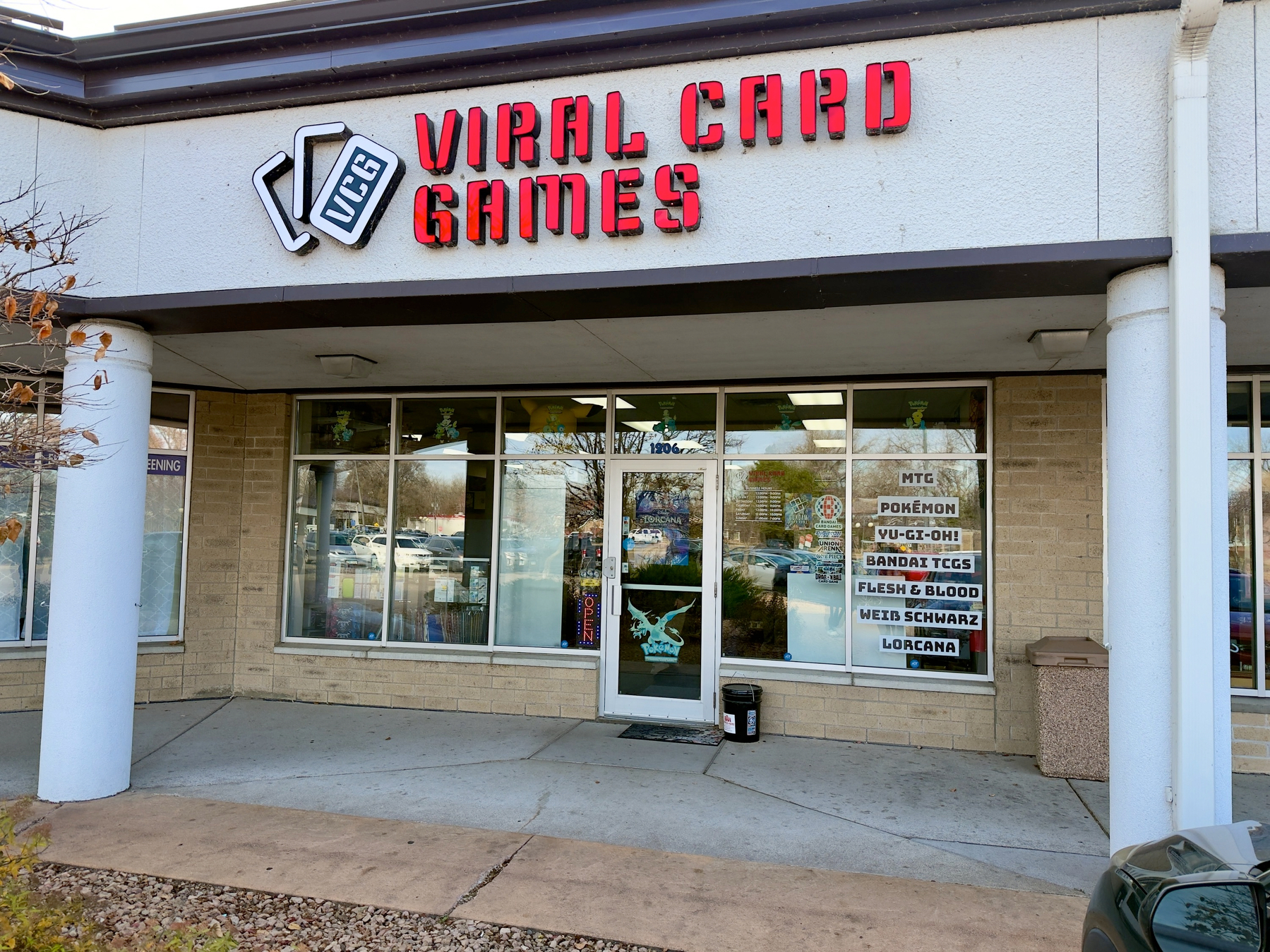 A storefront displays signs for Viral Card Games, featuring various trading card games like Pokémon and Yu-Gi-Oh!