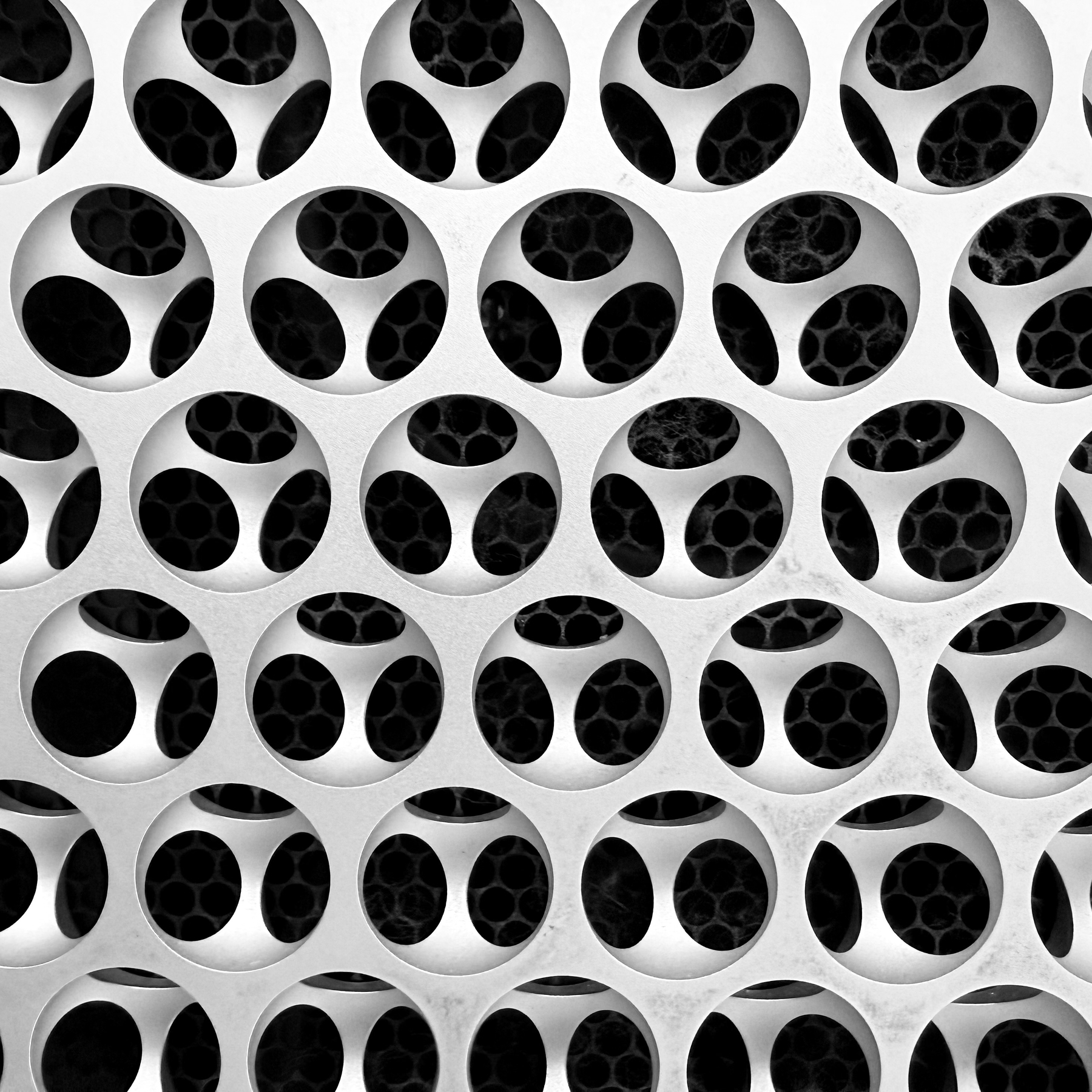 Auto-generated description: A grid of circular patterns with varying black and white hexagonal designs is displayed, creating an abstract geometric appearance.