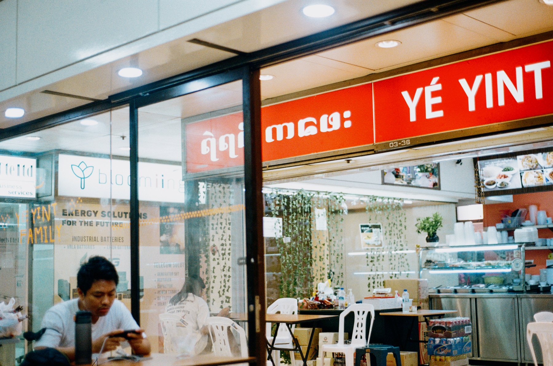 4. A scan of a color photo of a Burmese tea shop in Singapore. The signboard says Ye Yint