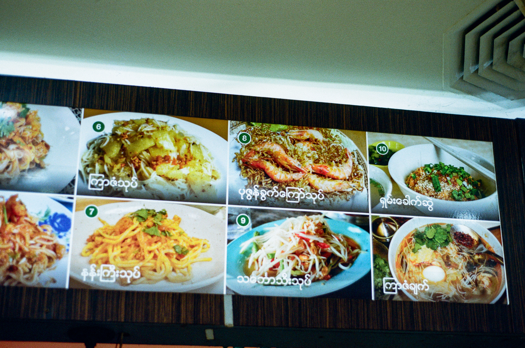 2. A scan of a color photo of a Burmese food menu at a restaurant, written entirely in Burmese