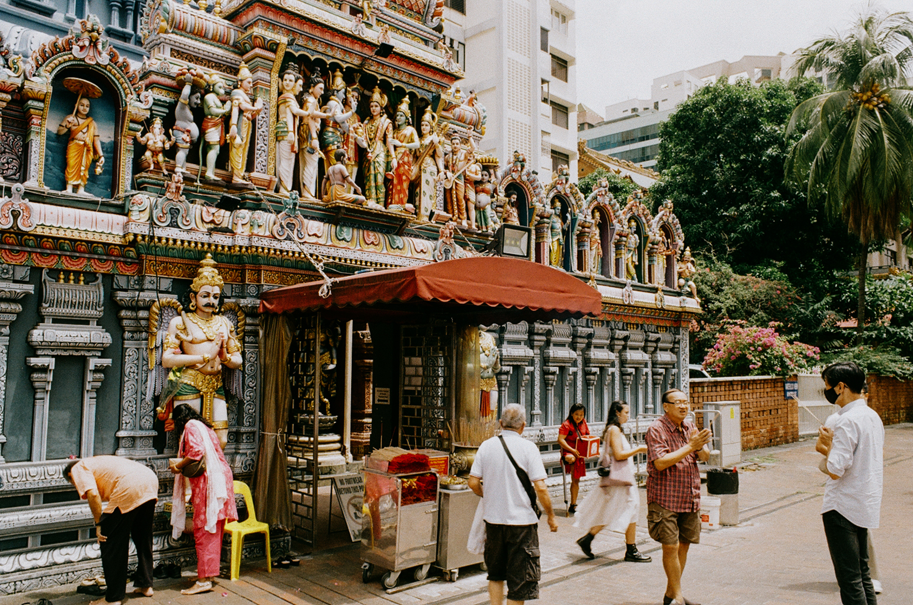 a scan of a color photo showing devotees praying at a Hindu temple in Singapore