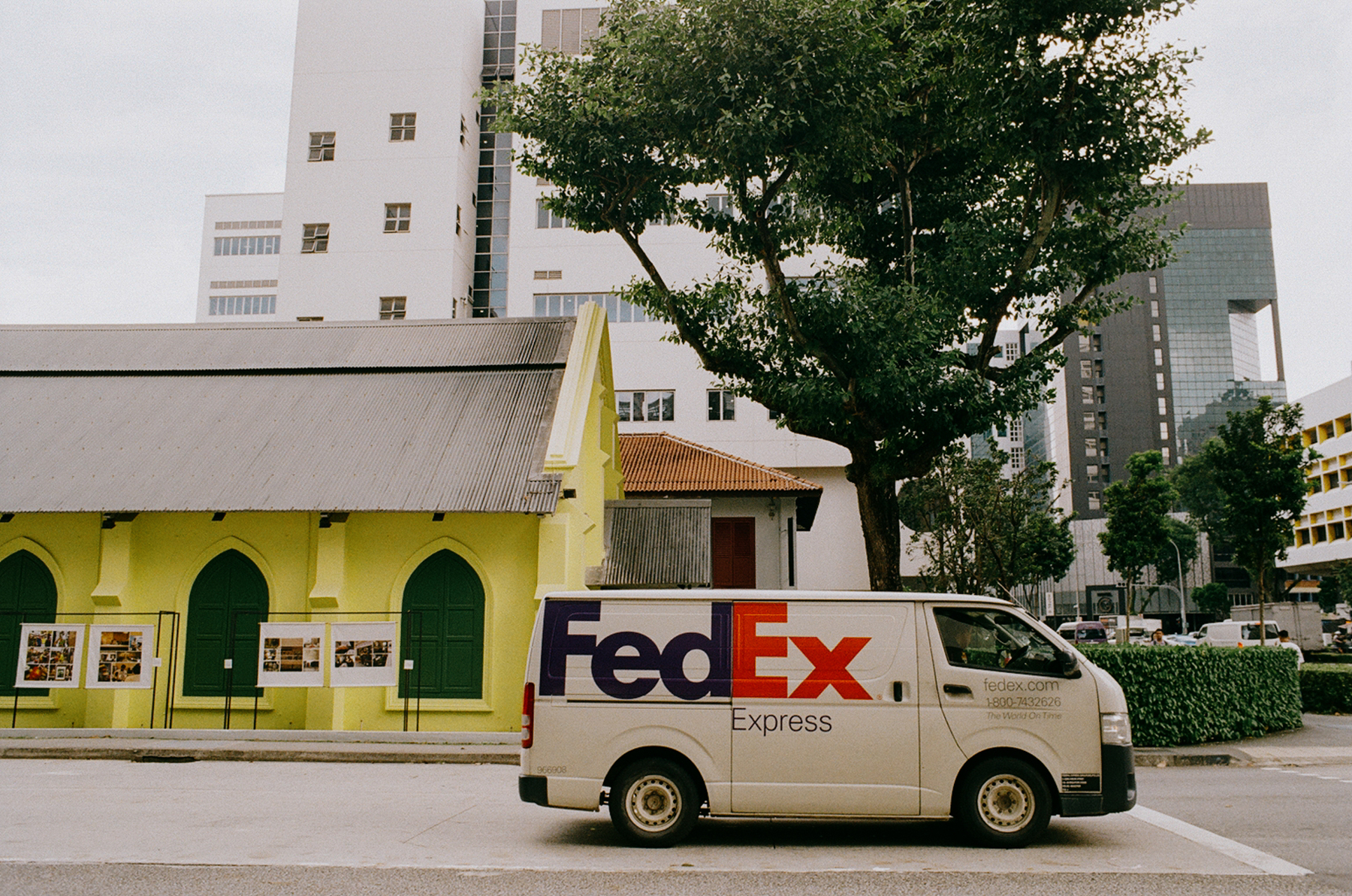 a scan of a color photo showing a fedex van by the side of a historical green building