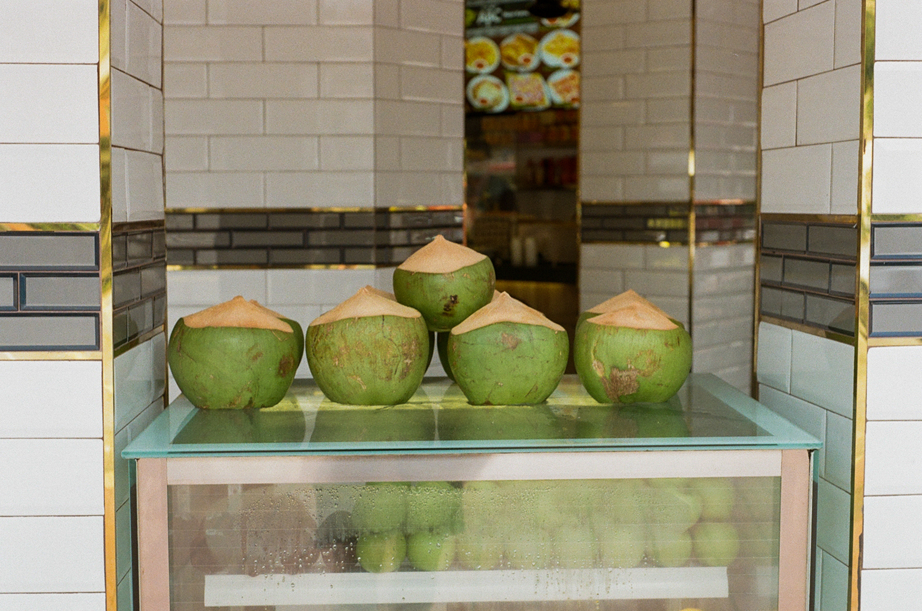 2. A scan of a color photo of coconuts sitting on a counter at a restaurant
