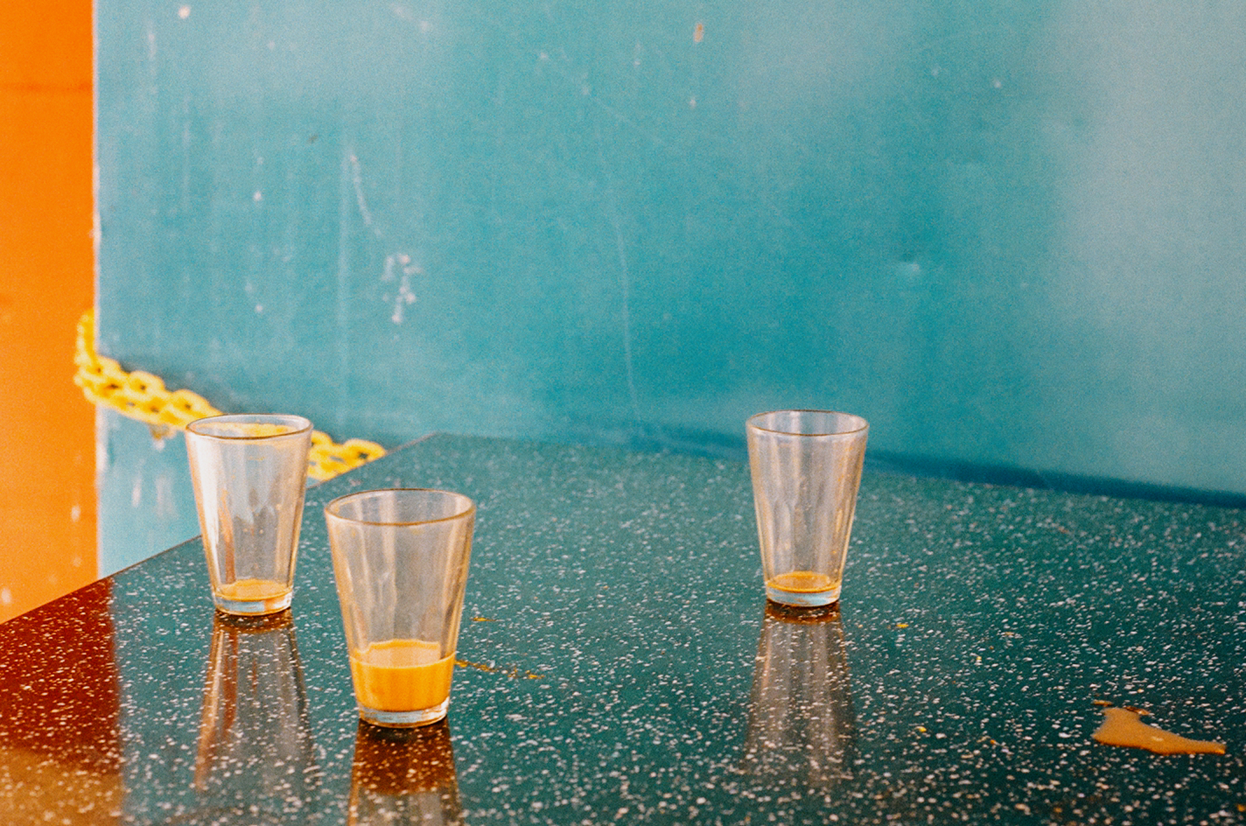 1. A scan of a color photo of three glasses on a table top in front of blue and tan walls