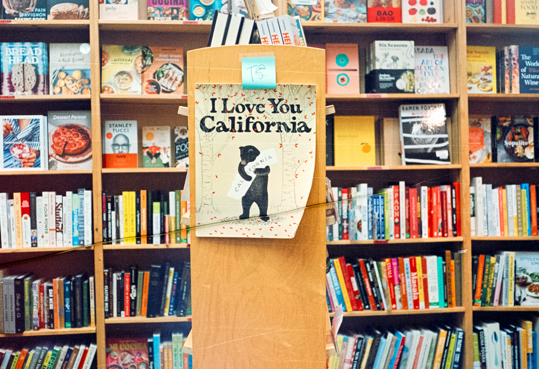 a scan of a color photograph that shows a poster that says I Love You California with a bear on it, in a bookstore in San Francisco