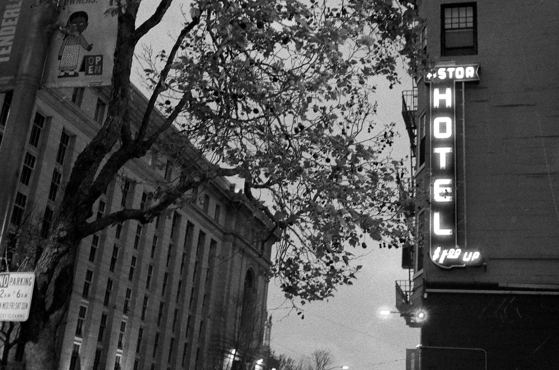 a scan of a black and white photograph of a hotel neon sign in Civic Center San Francisco