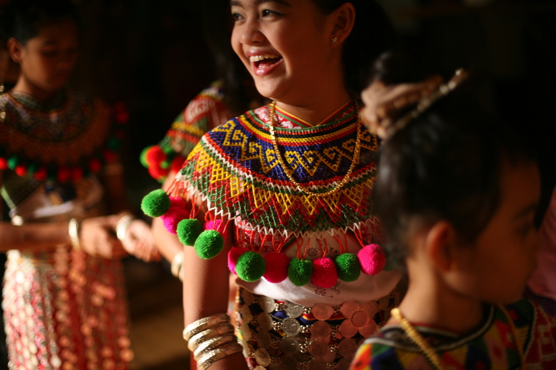 a color photograph of a young woman dressed in traditional Iban dress for the harvest festival