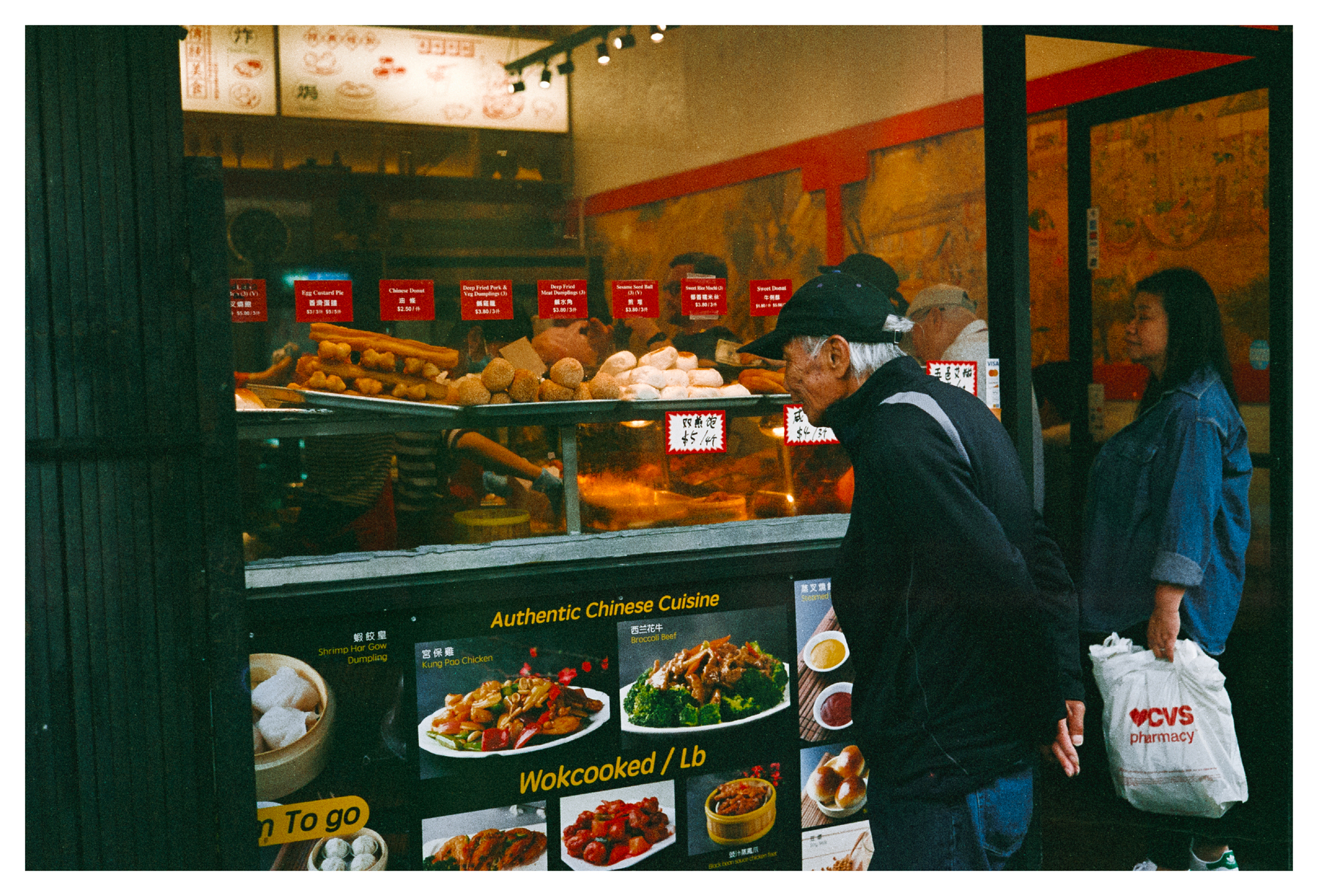 a scan of a color photo showing an old Chinese man looking into the window of a Chinese restaurant version 1
