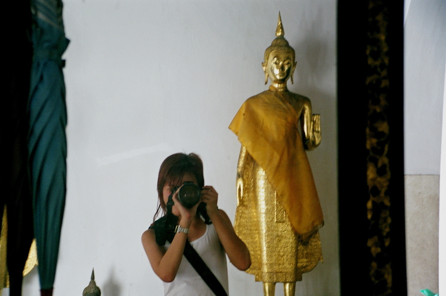 a person photographing a buddha at a thai temple