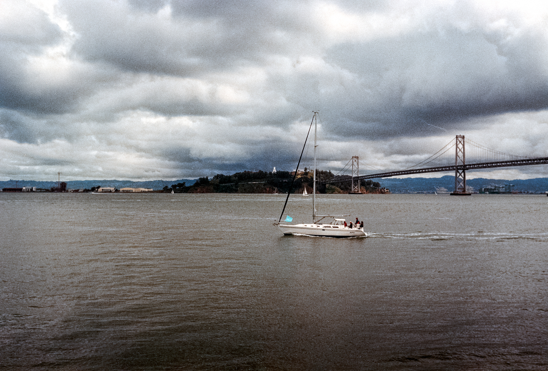 A scan of a color photograph of a group of people boating near the Bay Bridge