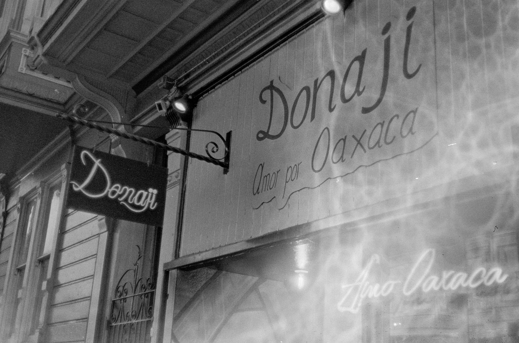 a scan of a black and white photo showing a Mexican restaurant called Donaji and its front door. There are a bunch of bubble patterns on the right side of the image