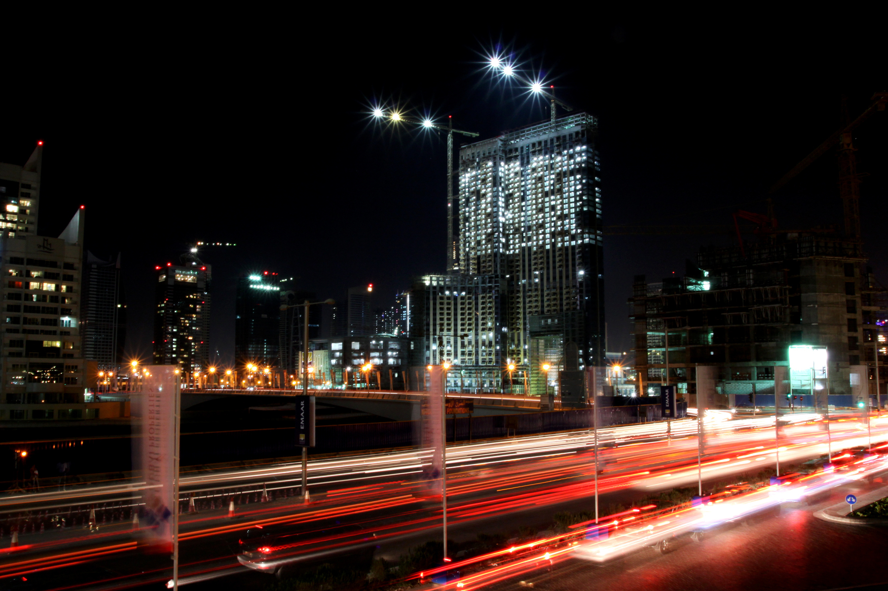 a digital photograph of a time lapse scene of Sheikh Zayed Road in Dubai with lots of construction and lights