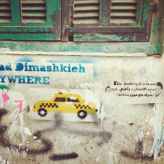 Some graffiti on a wall in Beirut with a yellow taxi and some stencils