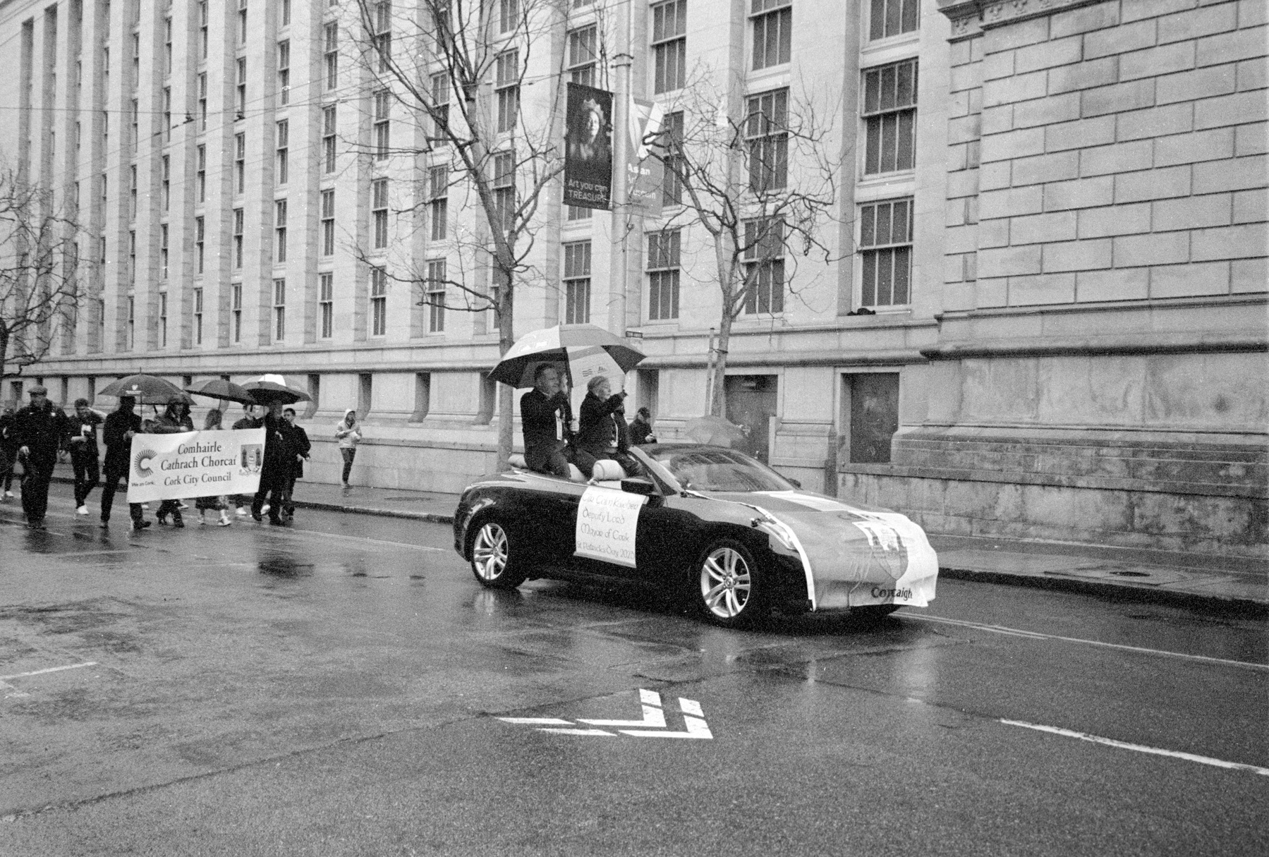 a scan of a black and white photograph of the mayor of cork, ireland, in a car in San Francisco's St Patrick's Day parade