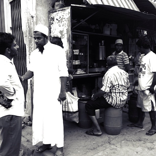 A black and white photo of some men in Sri Lanka at a tea shop