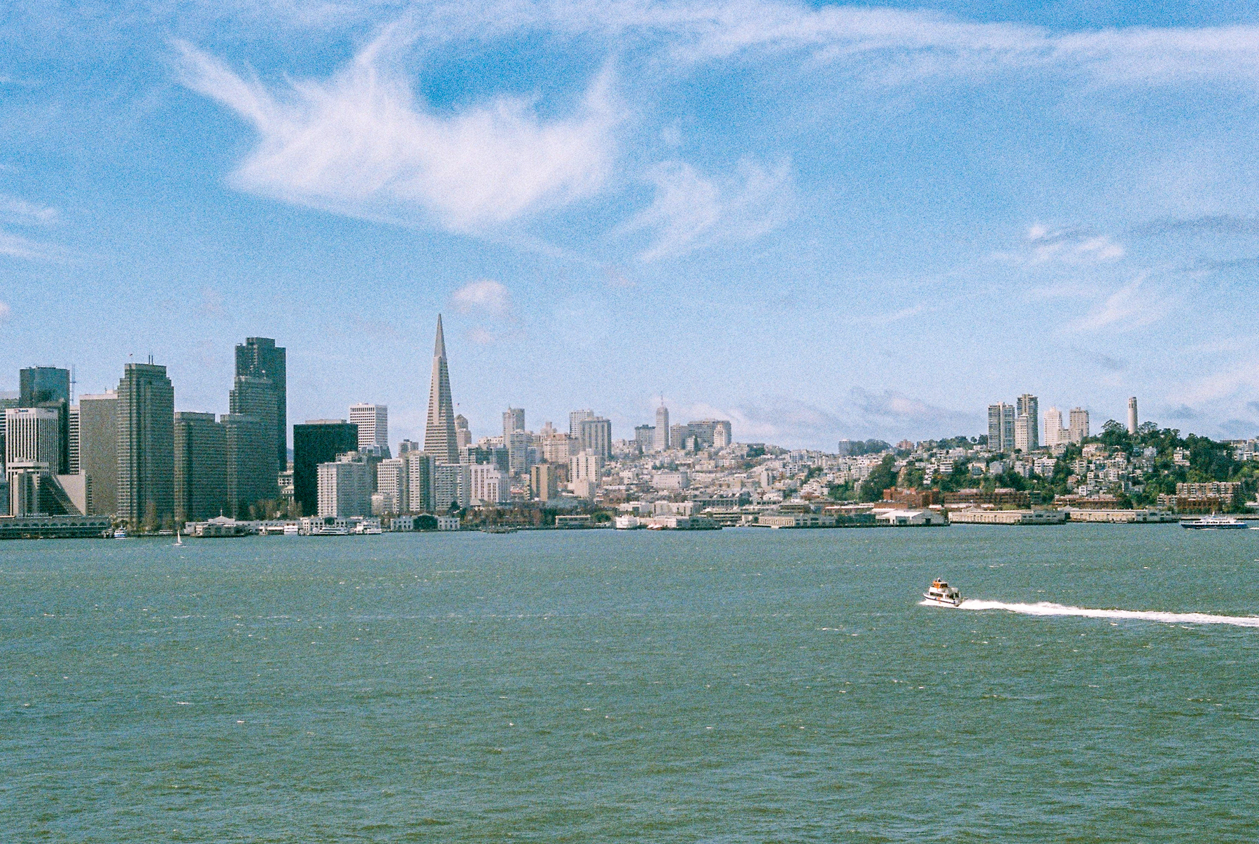 a scan of a color photo of the San Francisco skyline with a boat in the bottom right of the photo