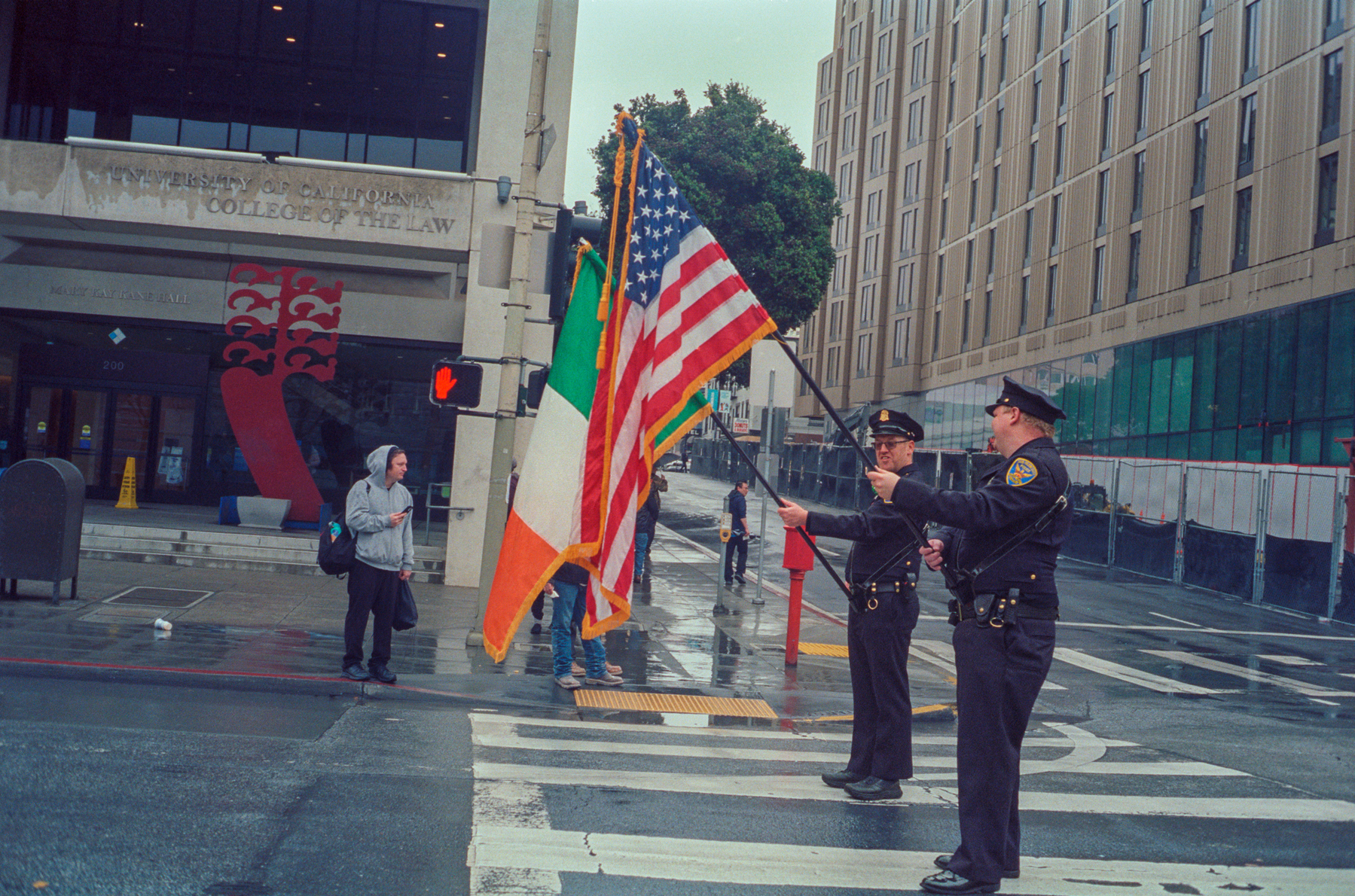 a scan of a color photograph of two cops holding flags. one american and one irish