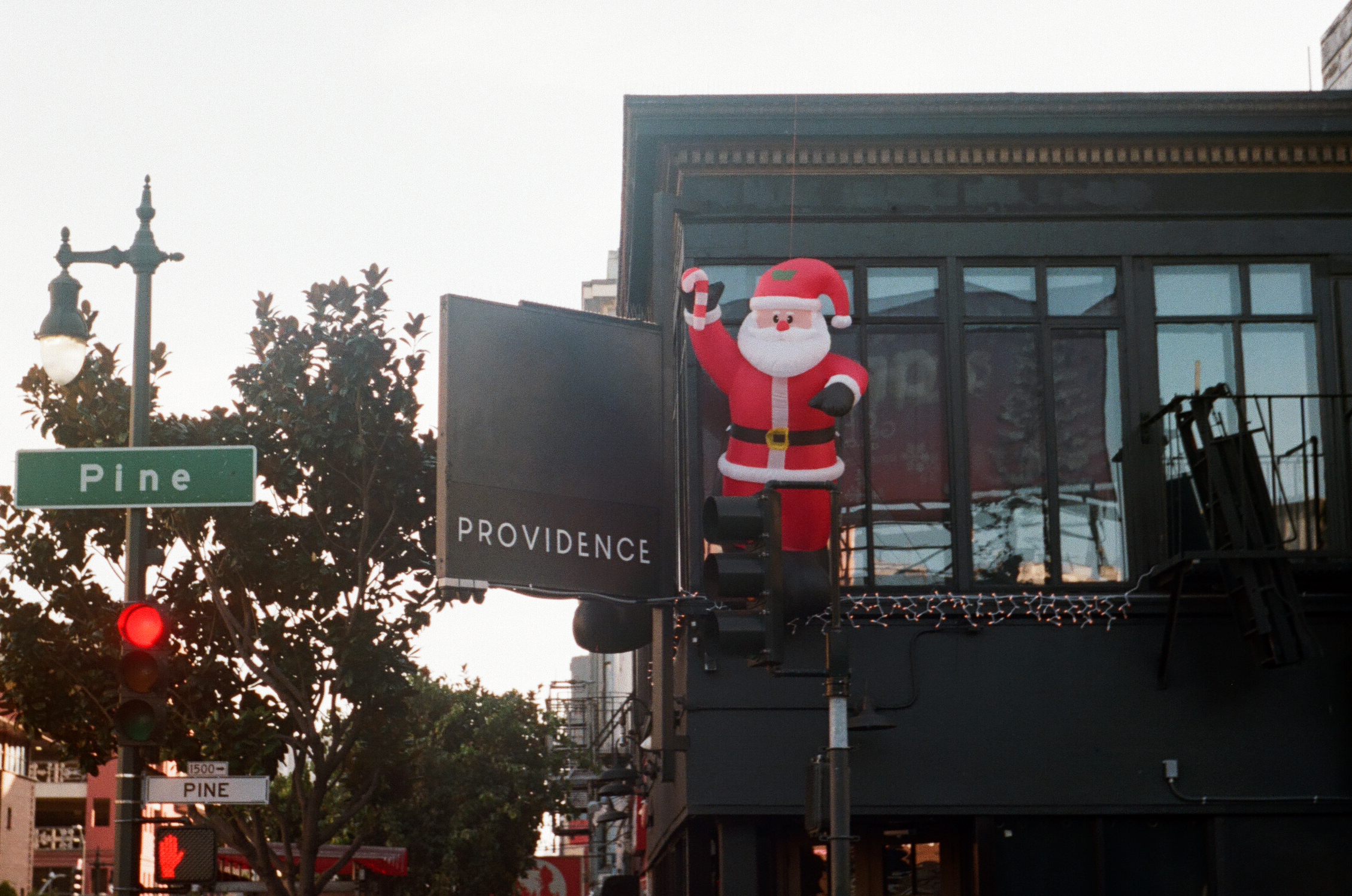 A Santa blow up hovering outside the second floor window of a club in San Francisco