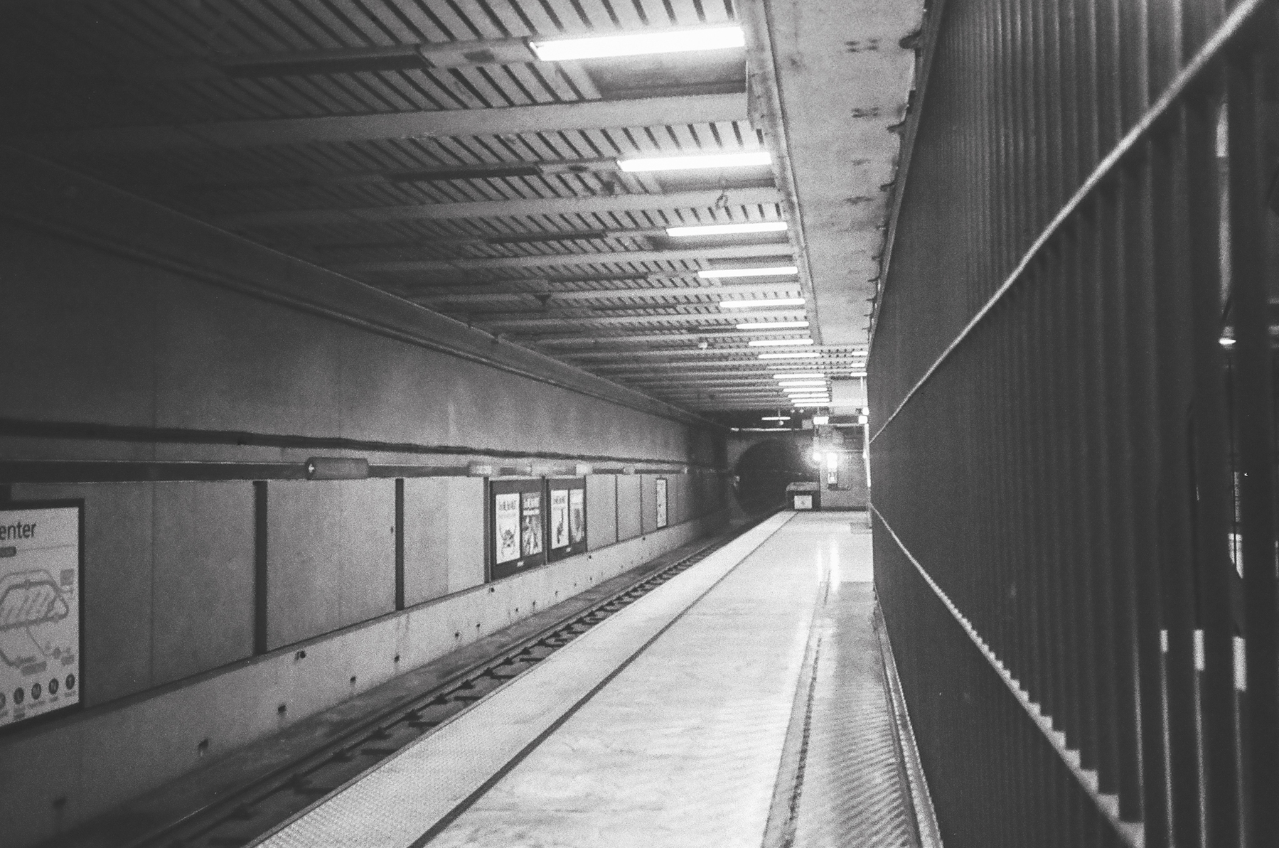 a scan of a black and white photograph of a train arriving in a tunnel in Muni Metro Civic Center station San Francisco