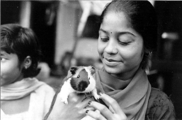 A black and white photo of a woman with her guinea pig