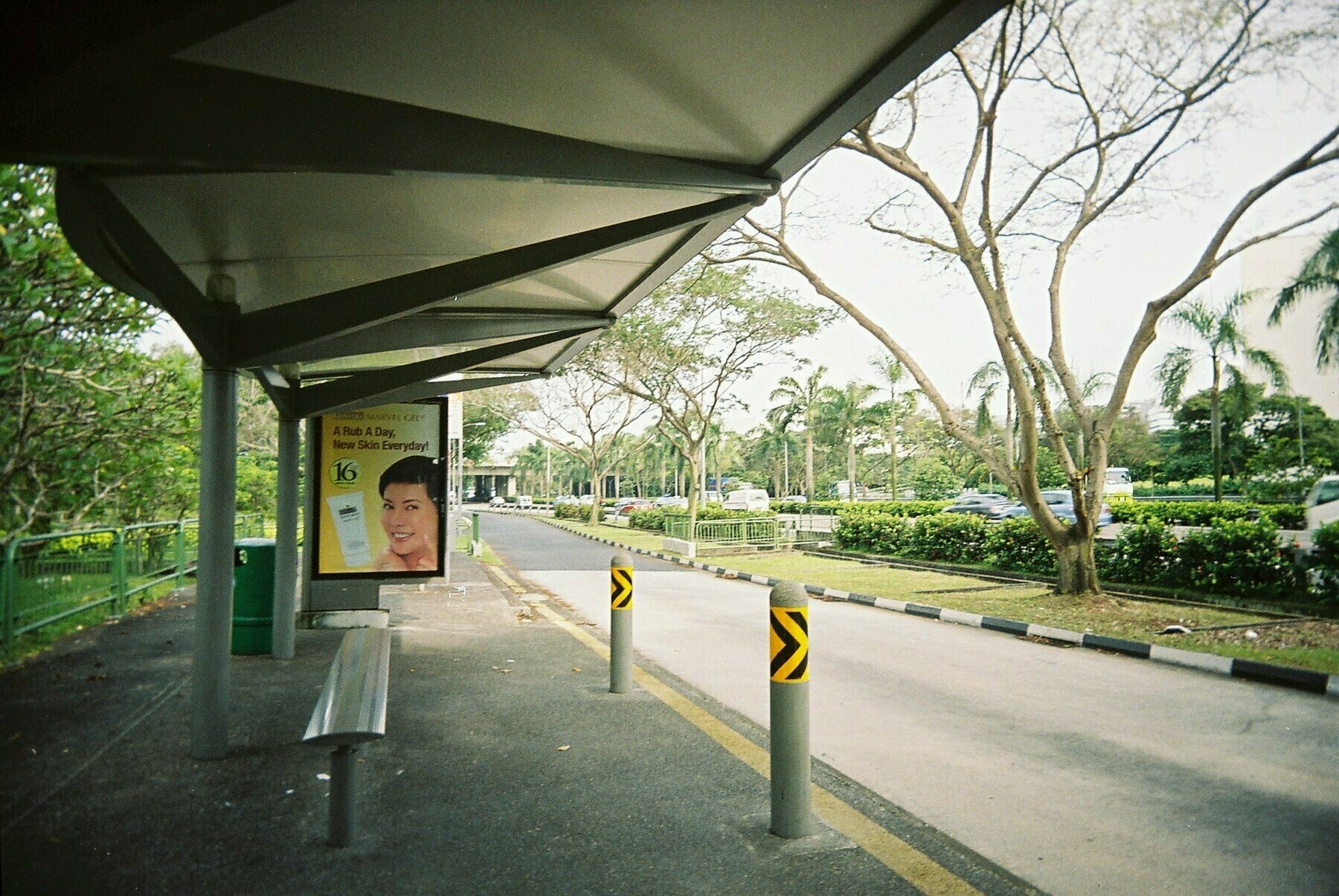 a scan of a color photograph of a bus stop in Singapore around 2006