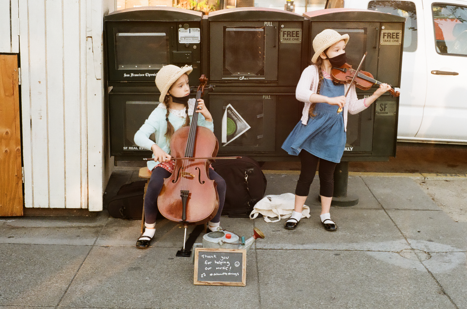 Two children playing string instruments on the streets of San Francisco