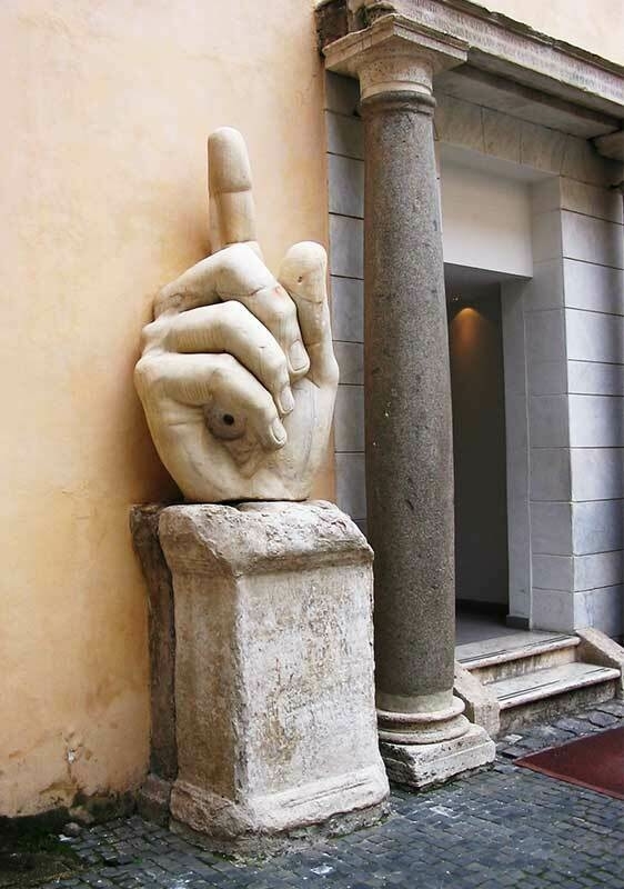 A giant Roman sculpture of a hand, with the index finger pointing skywards.