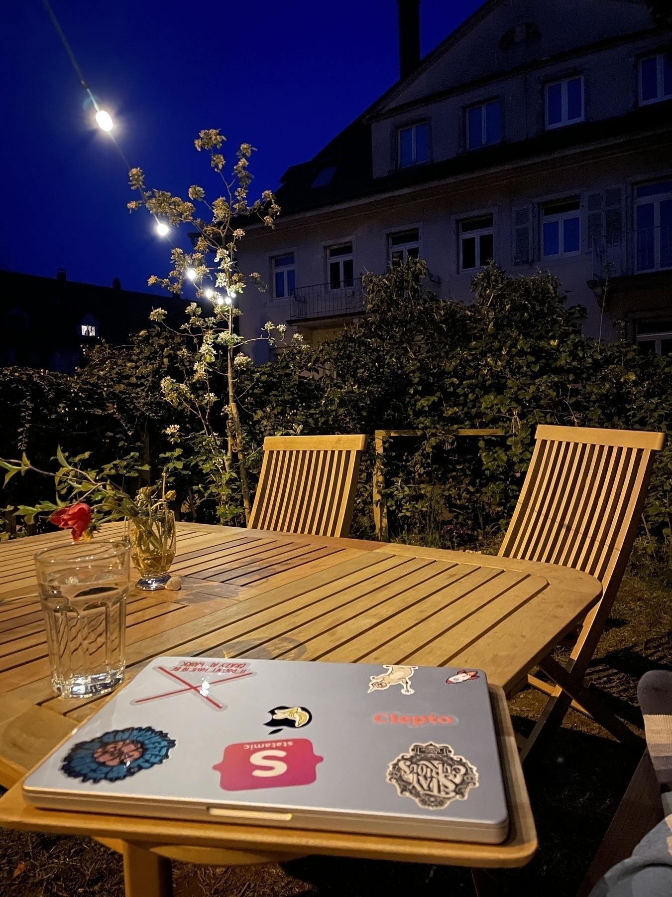 Garden furniture at Night, closed laptop laying on the table