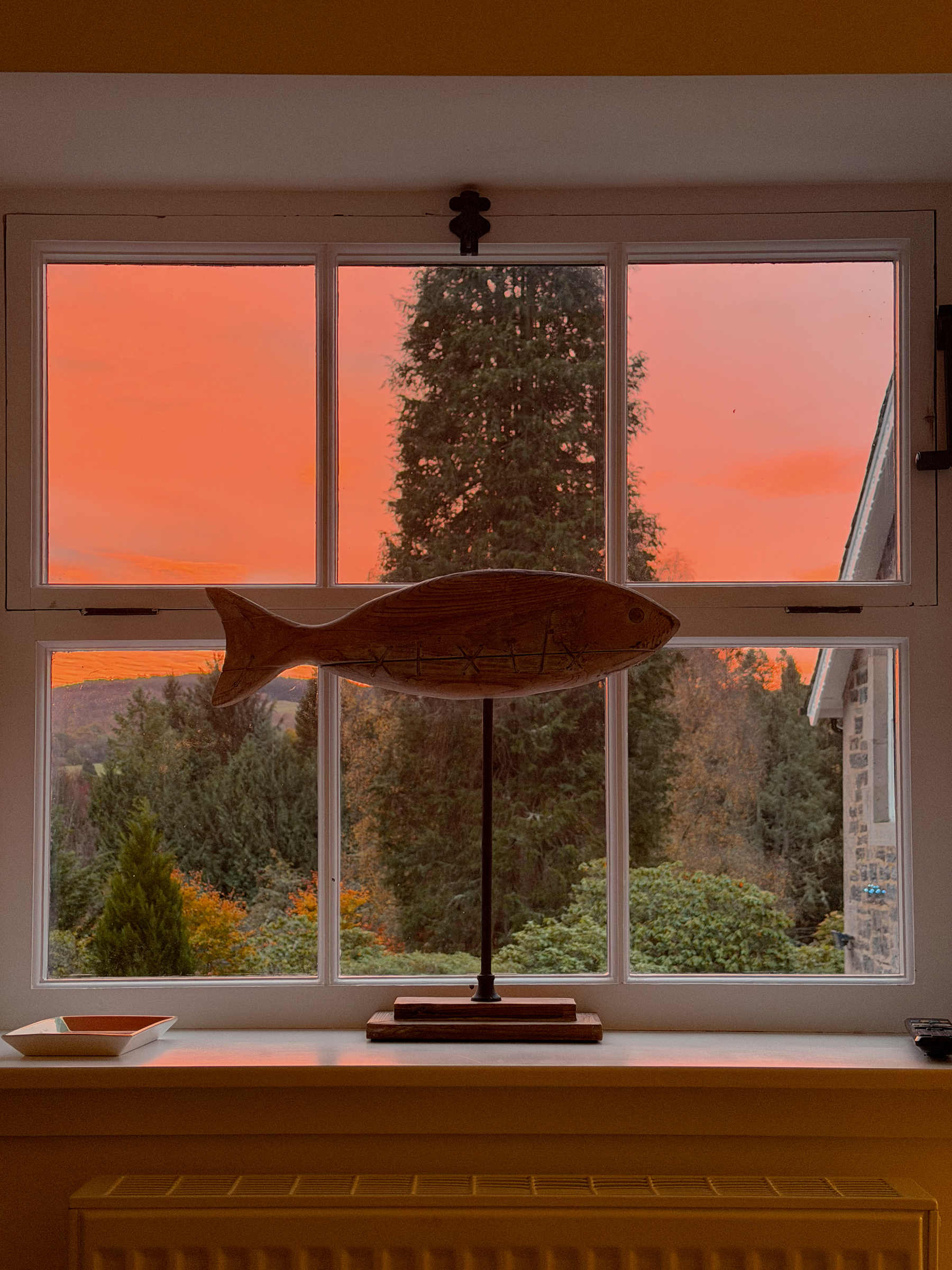 Sunrise through a small window with a fish decoration in front