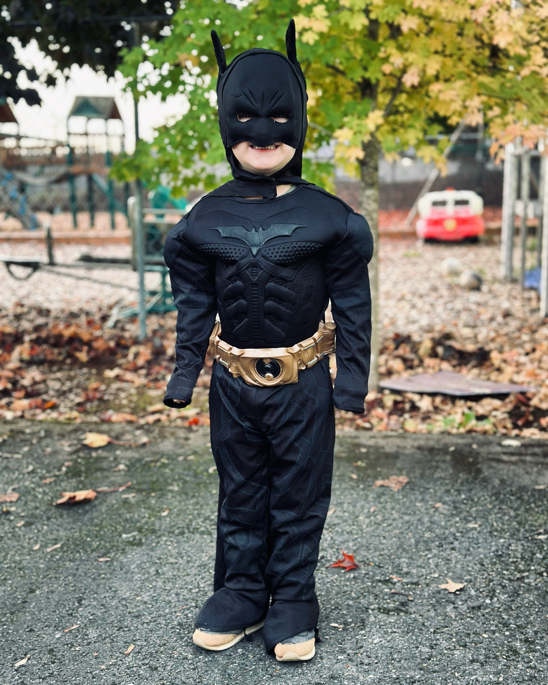 A 4 year old dressed as Batman, about to head into his preschool class. 