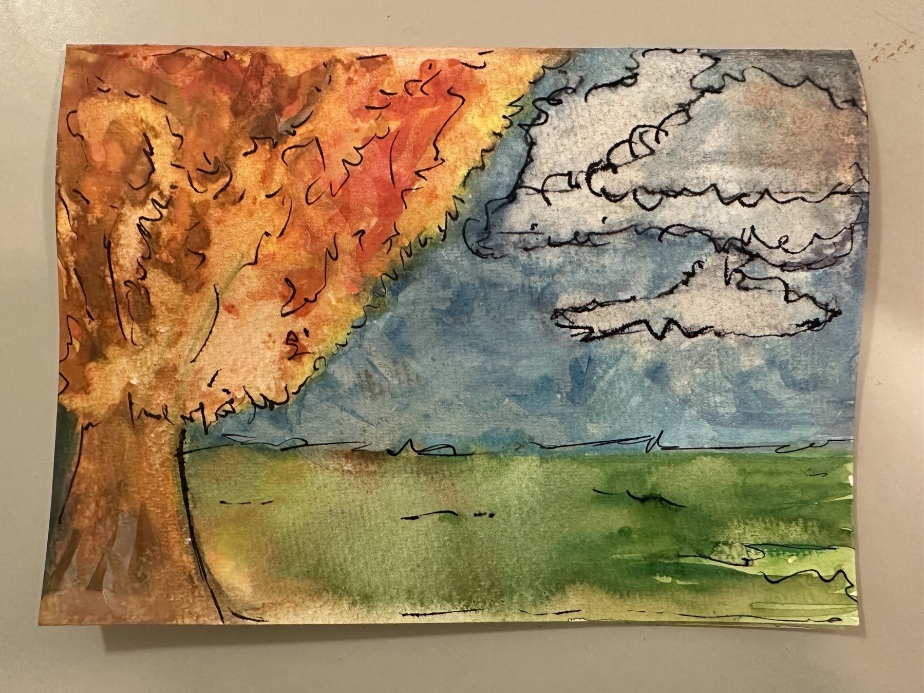 A vibrant watercolor painting depicts a tree with orange and yellow leaves against a blue sky with clouds and a green field.