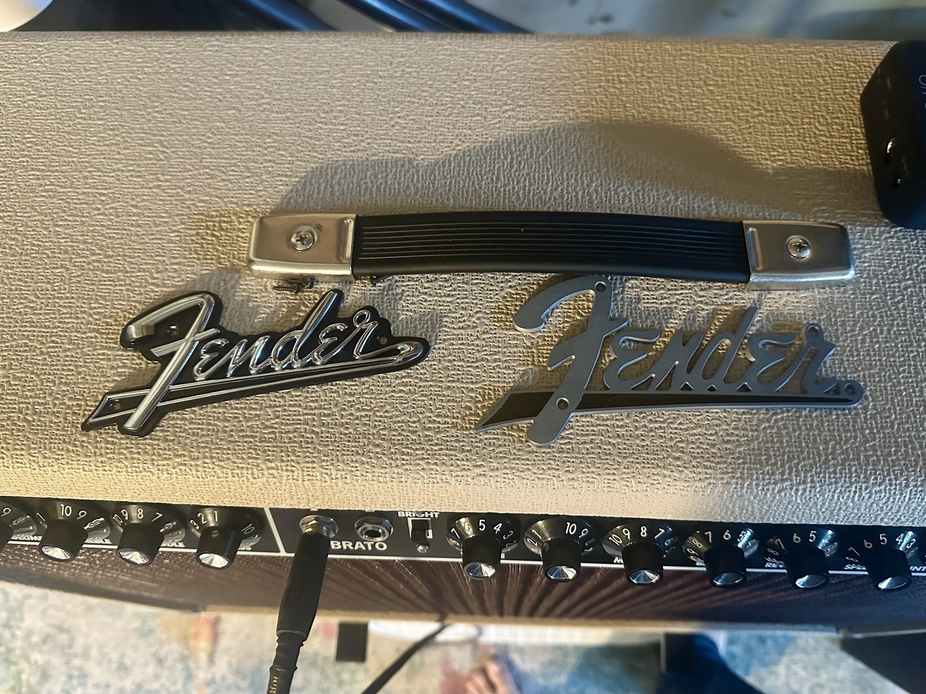 Two Fender logos are placed on top of a Fender amp.