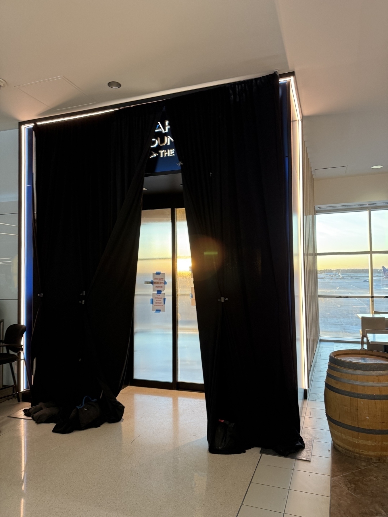 A black curtain covers a glass set of doors with the Chase Sapphire logo obscured above it