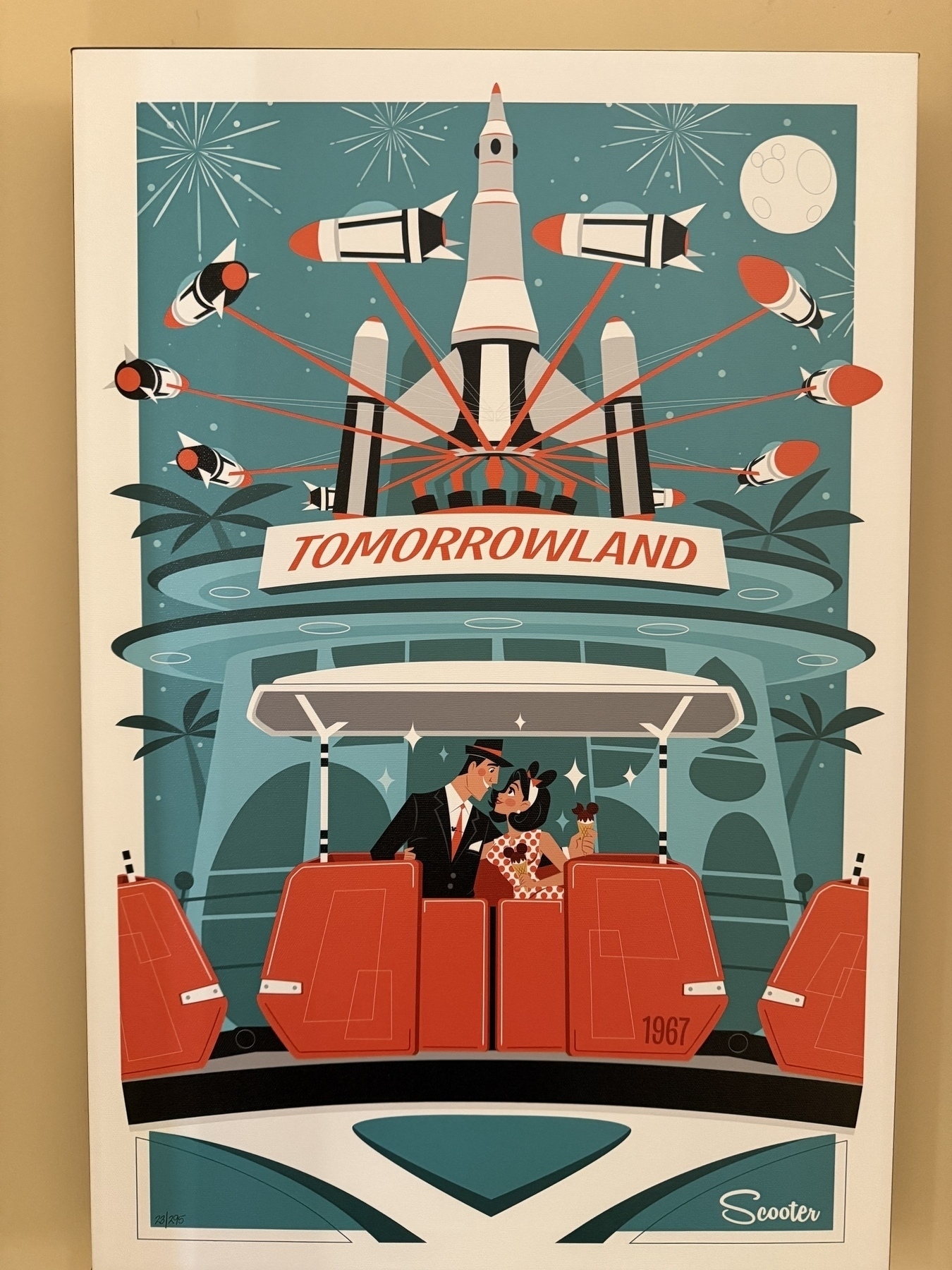 Artwork by Scooter. A blue background with a couple sitting in an orange PeopleMover cab with a “Tomorrowland” sign above them, with the Rocket Jets attractions spinning above.