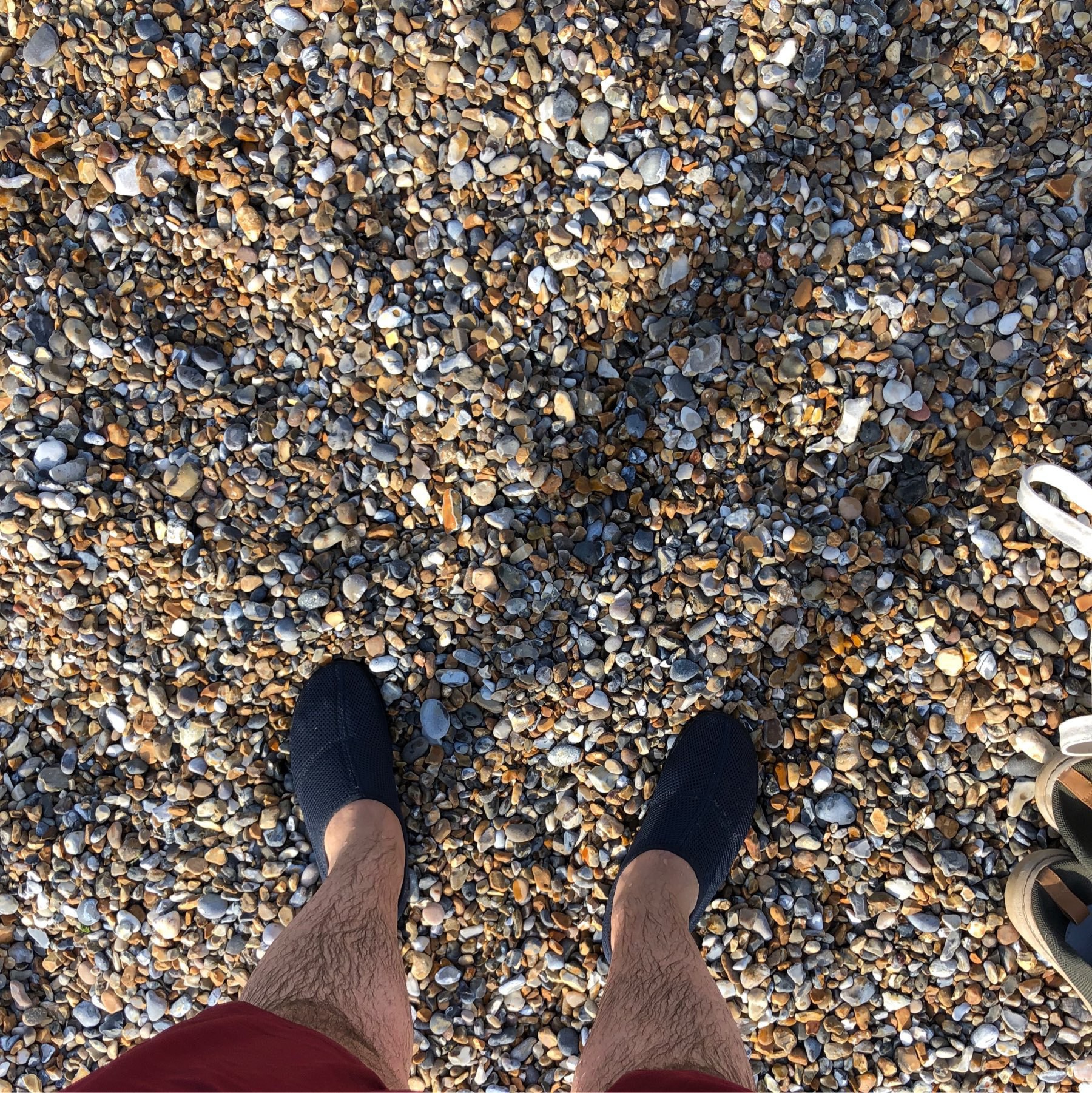 My legs in the pebbly beach.