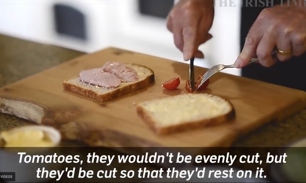 Small cut of the video of the man cutting tomatoes, you can also see a ham sandwich.