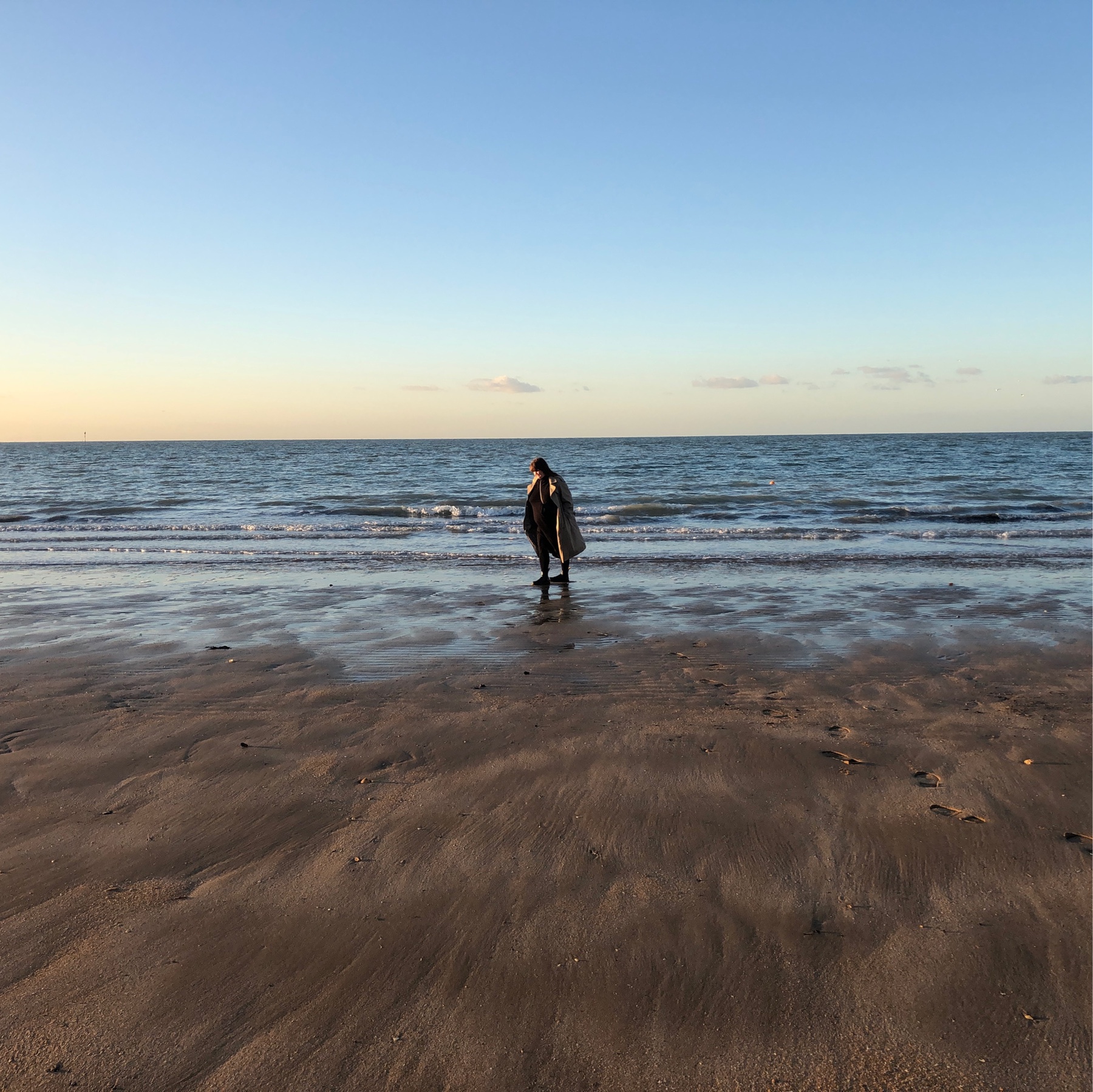 Anna walking on the sea, low tide blue skies