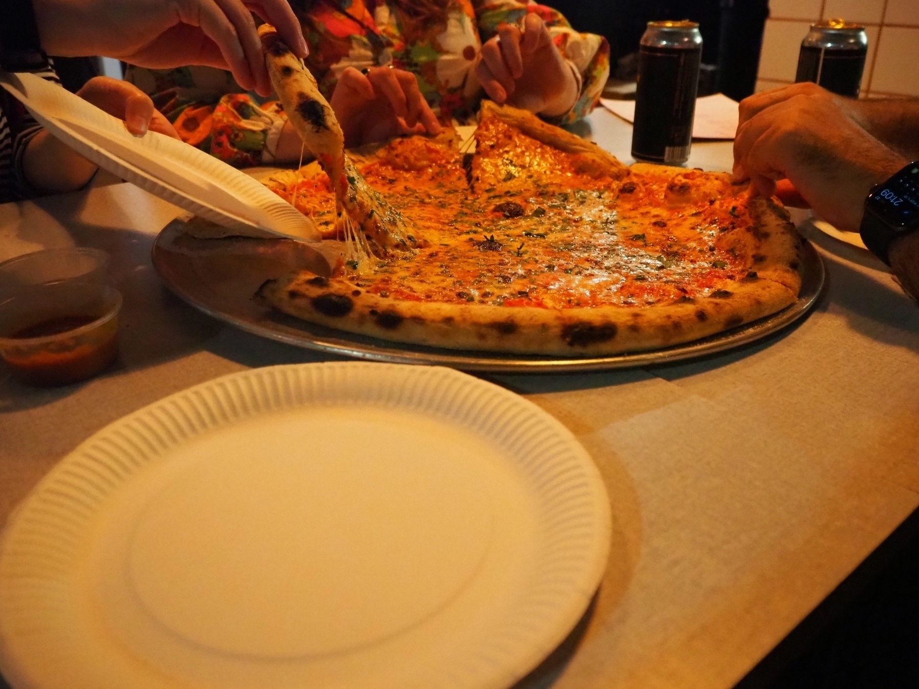 Large pizza, people picking slices on each side