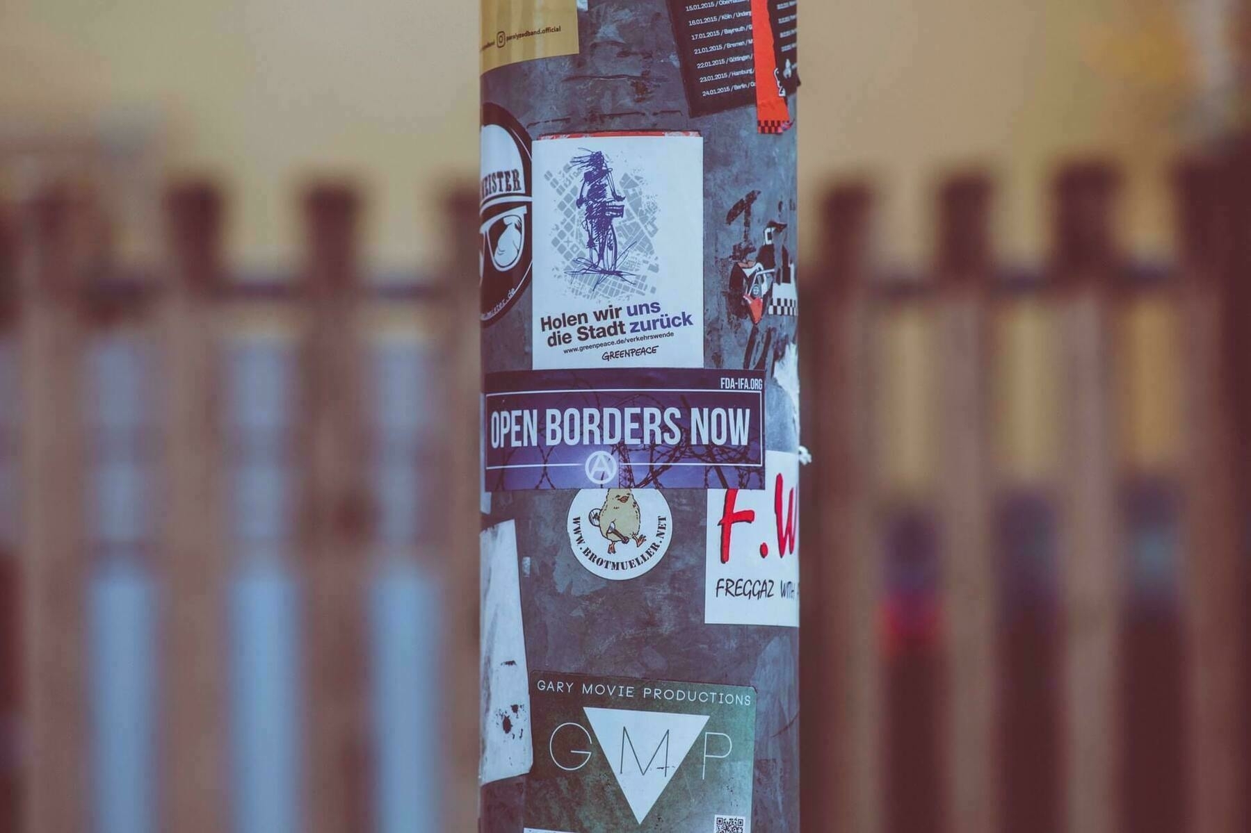 Lamp post with sticker saying 'Open Borders now'