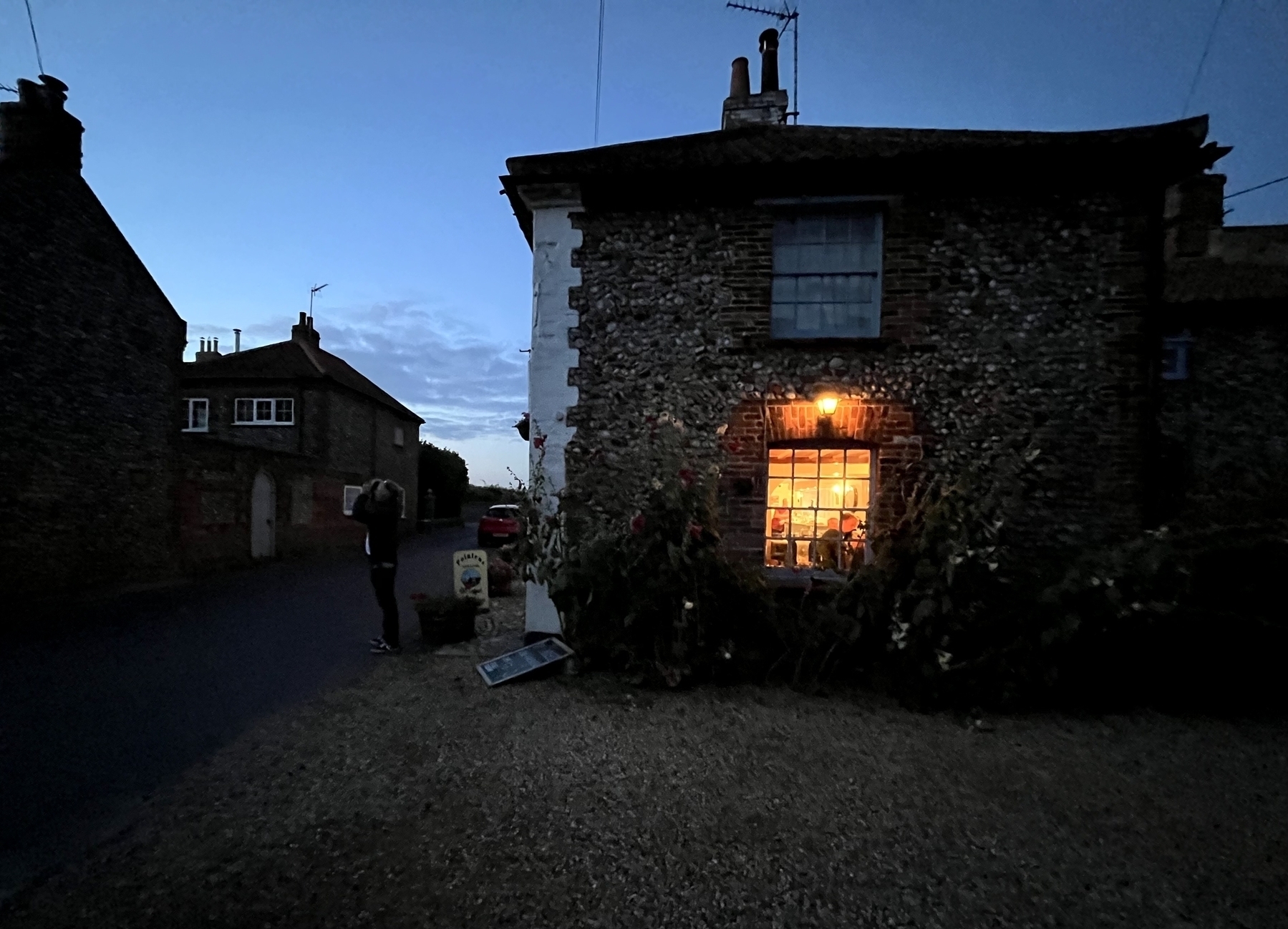 House with a light on the right hand side, it’s dark, pebble wall