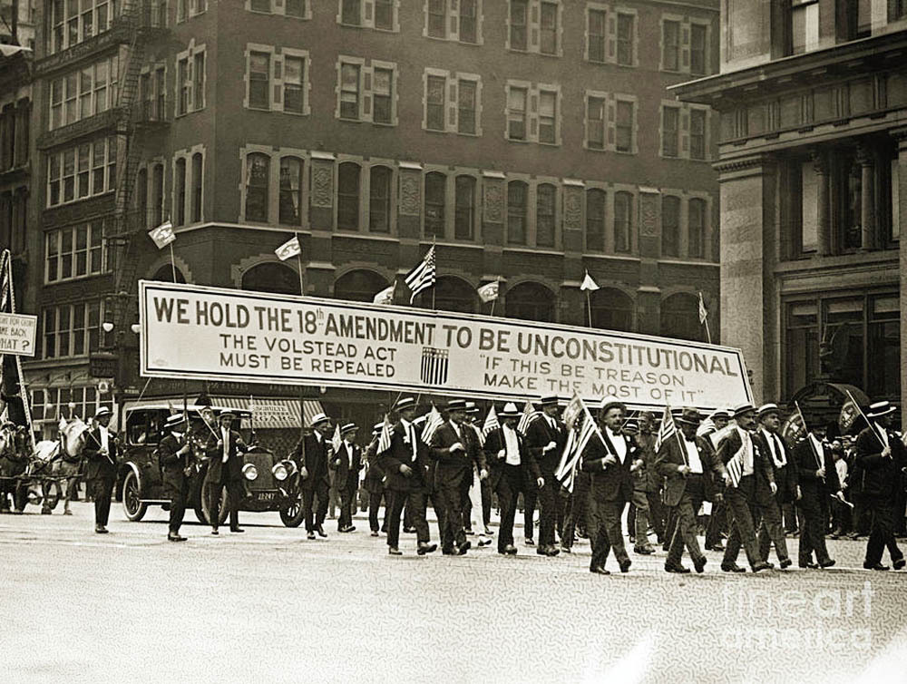 Demonstrators carry a banner through the streets of New York during a 4th of July anti-Prohibition parade, 1920s. The banner reads “WE HOLD THE 18th AMENDMENT TO BE UNCONSTITUTIONAL. The Volstead Act Must Be Repealed. If this be treason, make the most of it.”