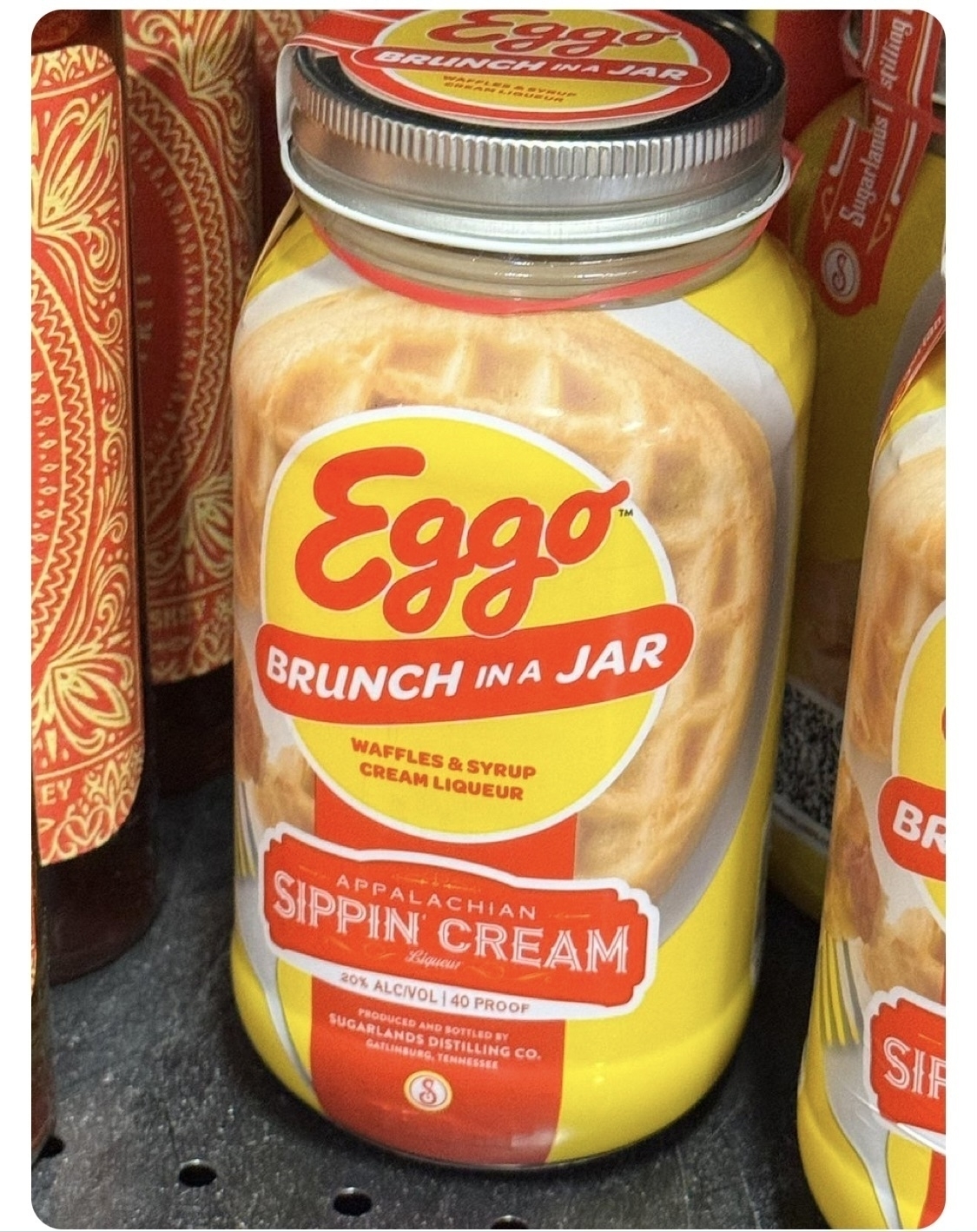 A sealed glass jar with a printed commercial label "Eggo Brunch in a Jar waffles & syrup cream liquer Appalachian Sippin Cream" with additional small print that I am becoming too nauseated to transcribe