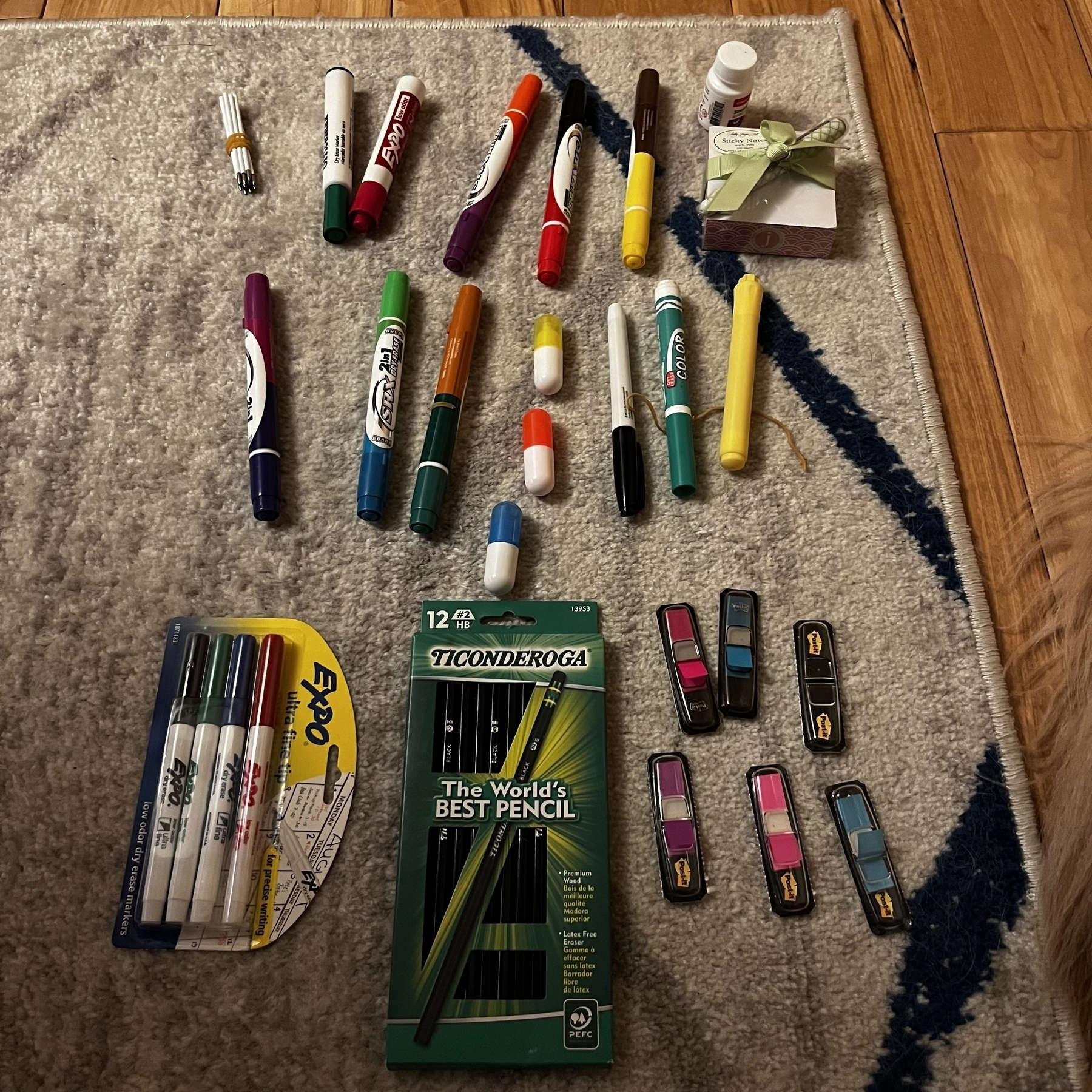 Markers, paper, pencils, and bookmarks arranged on the floor.