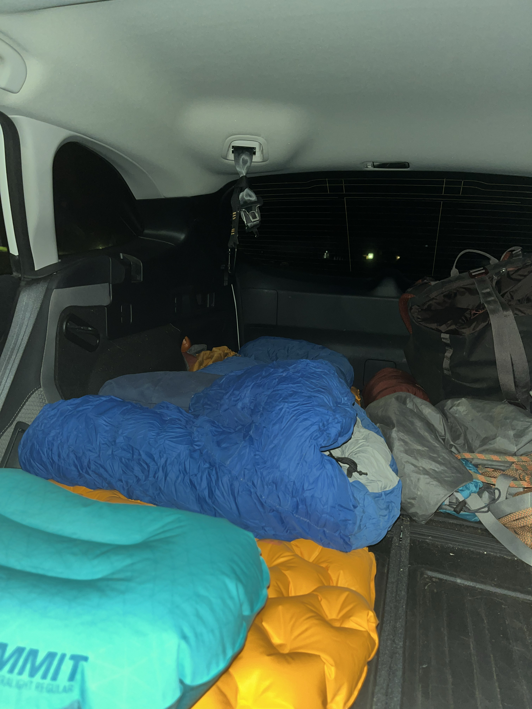 Back of a Subaru Outback with sleeping bag setup.