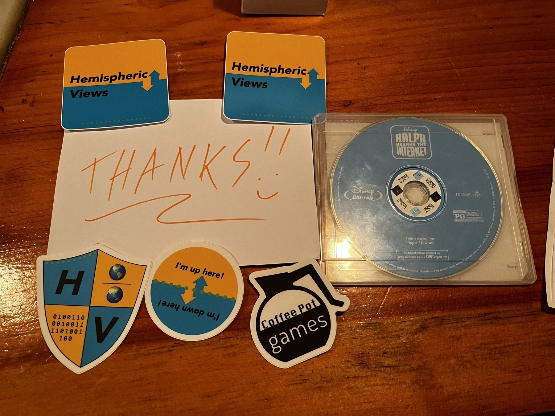 A thank you sign with Hemispheric Views podcast stickers and a ‘Ralph Breaks the Internet’ Blu-ray Disc.