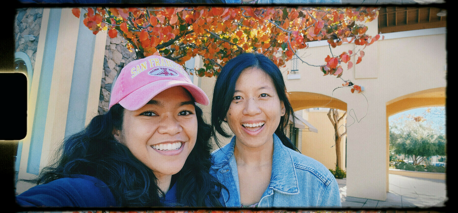 K— (left) and Kristine (right) in front of a tree with red orange leaves