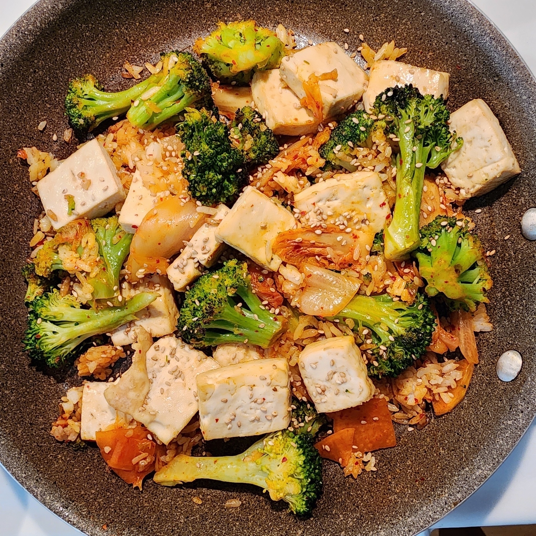 Tofu, broccoli, kimchi, and rice combined in a skillet