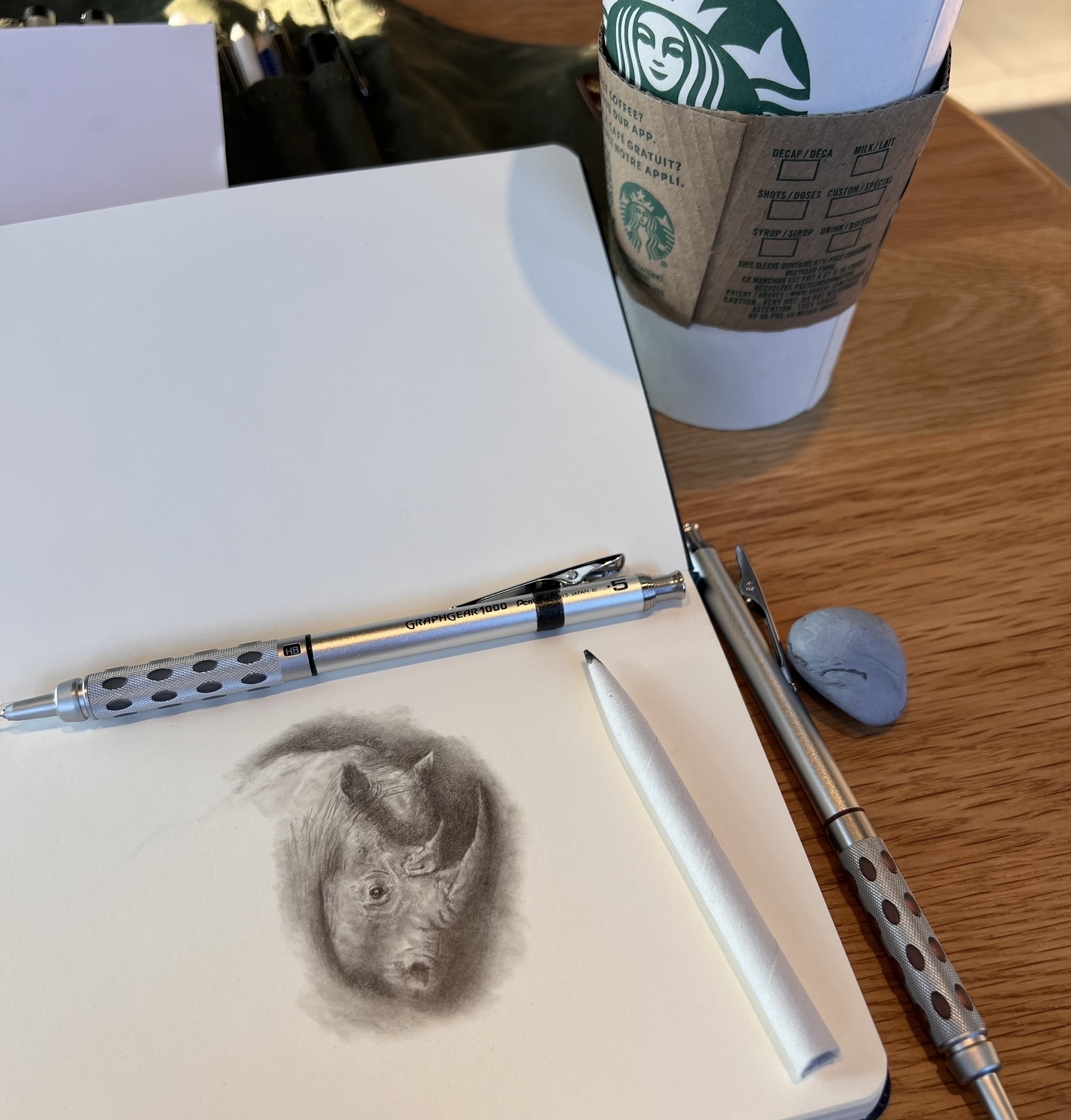 A pencil sketch of a rhino in a coffee shop