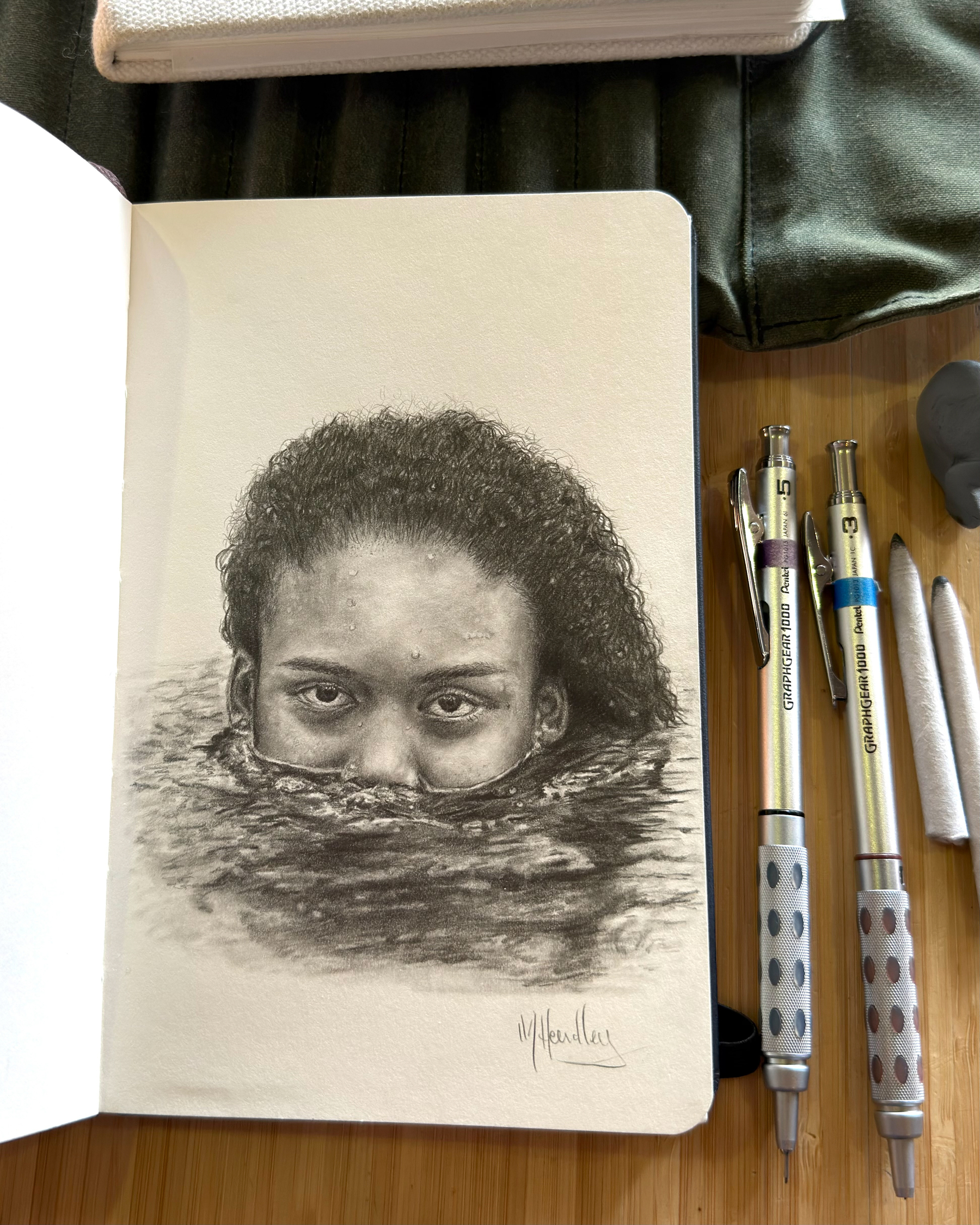 Graphite drawing of a woman's face partially submerged in water, only her eyes, forehead, and textured curly hair visible above the surface.